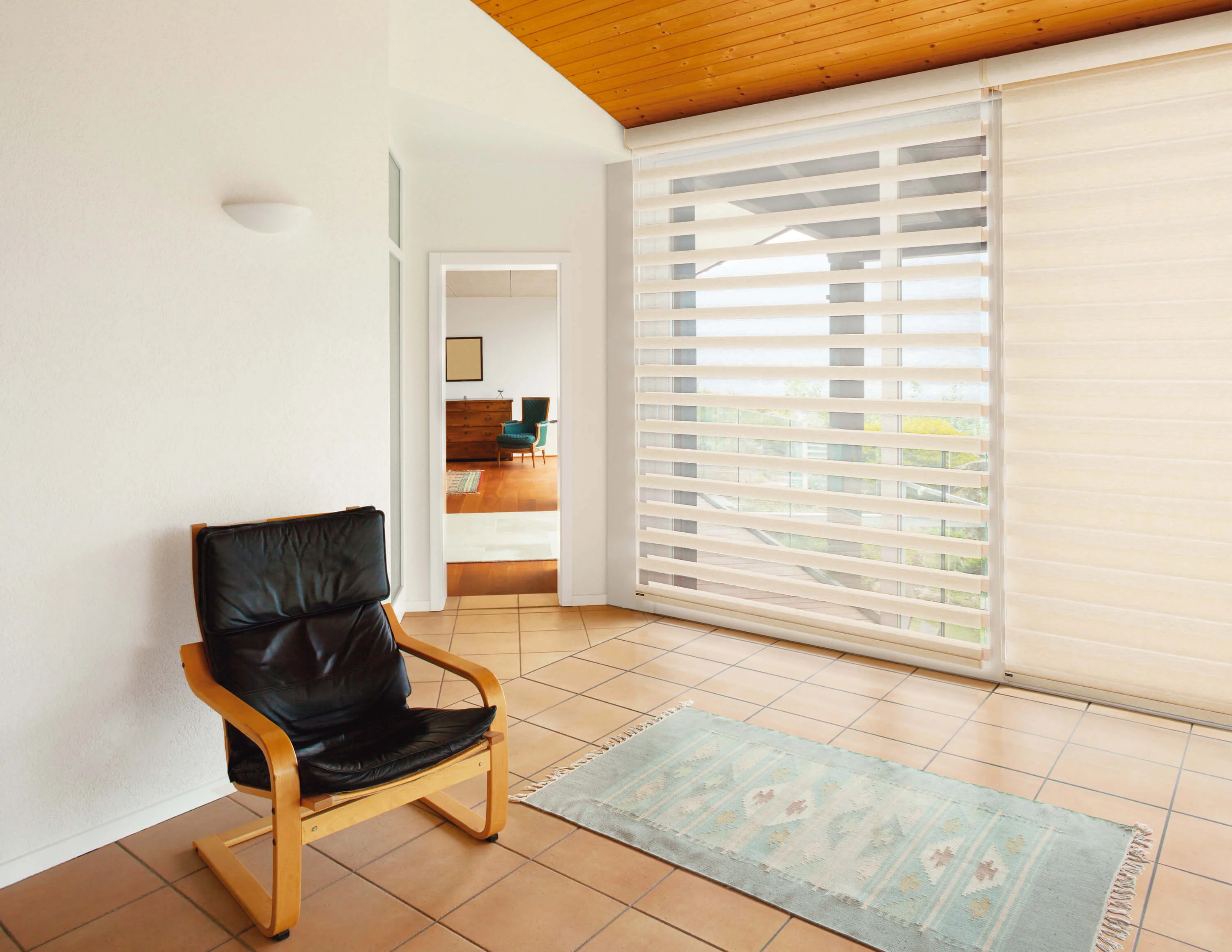 Bright living room with modern mid-century furniture and large horizontal shutter windows demonstrating cordless mechanism