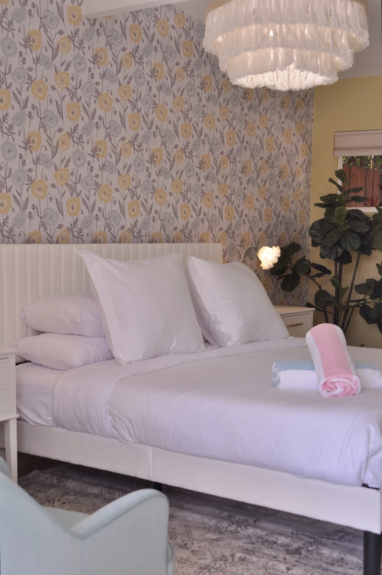 Boutique hotel Palm Springs romantic suite bedroom with white king bed, floral wallpaper, crystal chandelier, and elegant