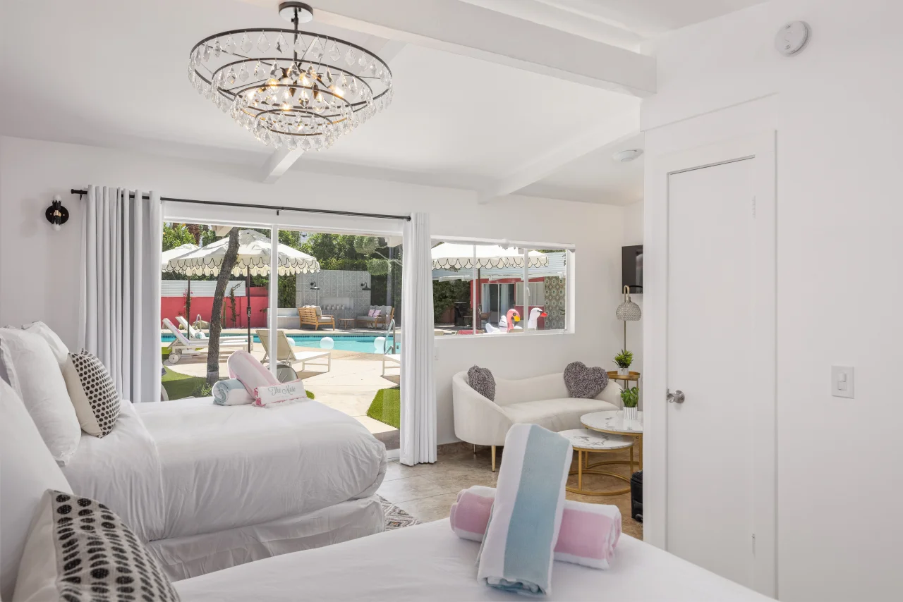 Luxurious romantic hotel bedroom suite in Palm Springs with crystal chandelier, plush bedding, and direct pool access