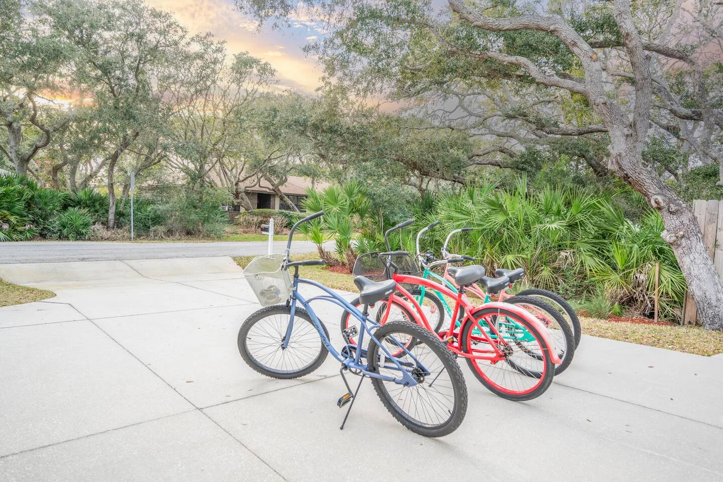 Colorful bicycles parked at property entrance with oak trees, vacation rental amenity in St. Augustine