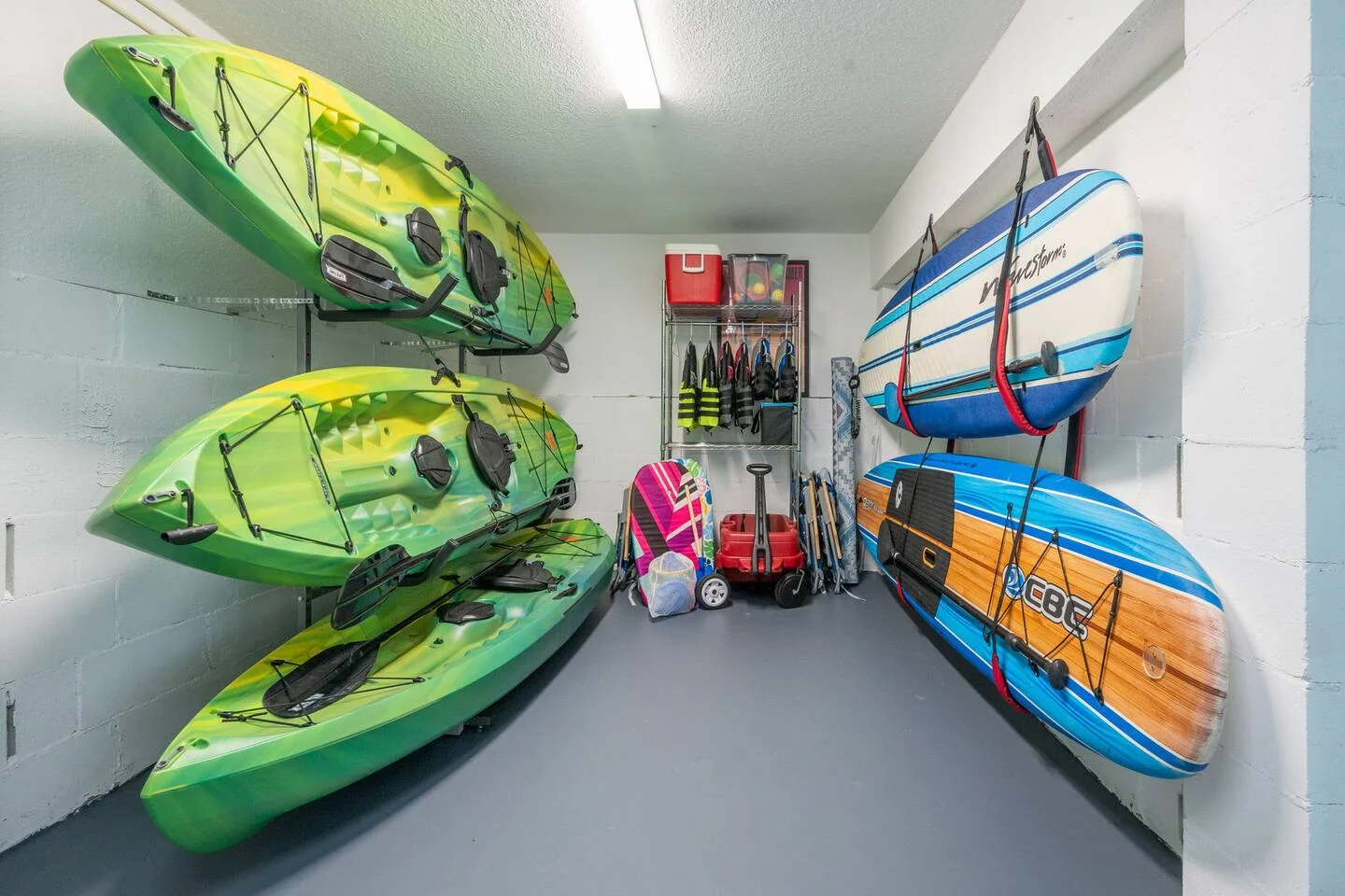 Organized storage room with kayaks and paddleboards for managing an Airbnb in St. Augustine with water sports amenities