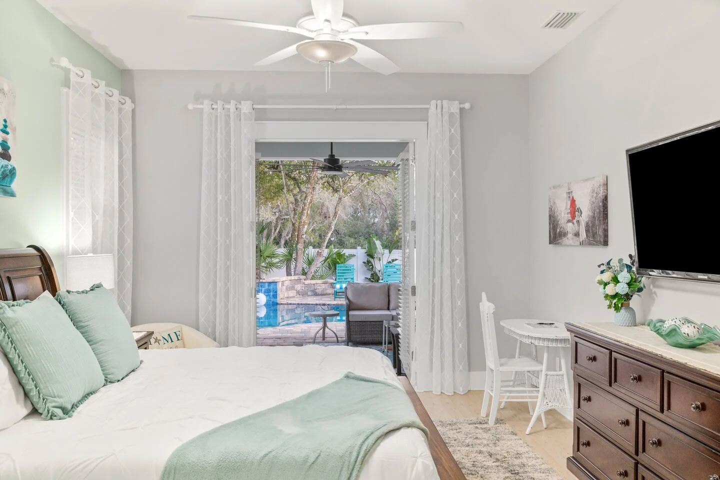 Master bedroom with mint green bedding and pool patio access in St. Augustine FL property management rental