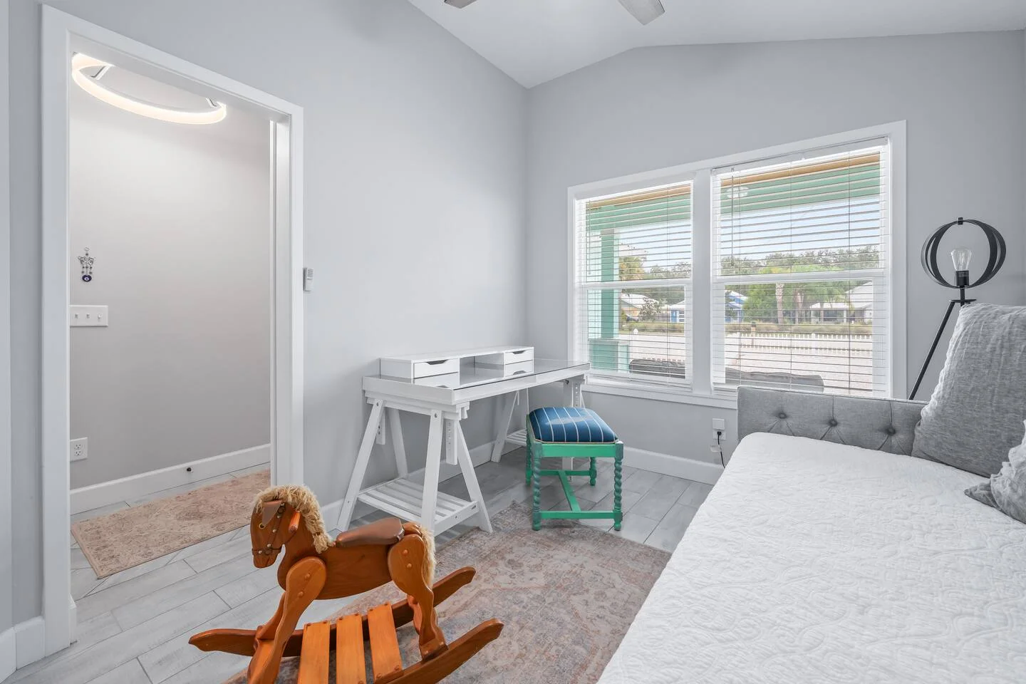 Modern vacation rental bedroom showcasing biophilic design with ocean views, natural wood flooring, and potted plants