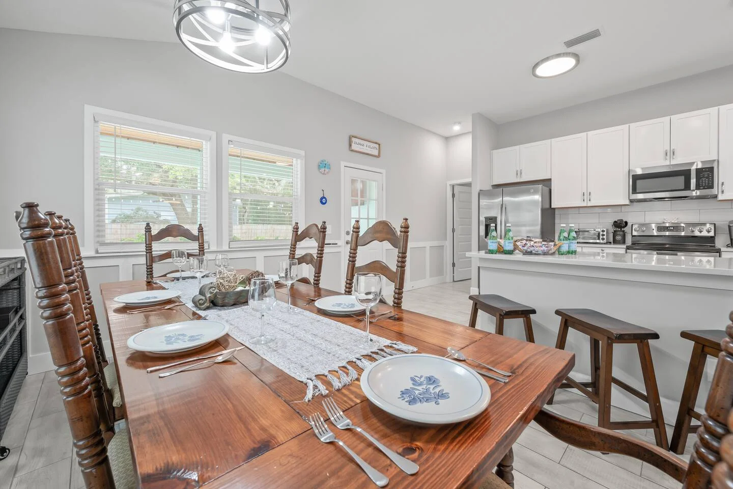 Bright open concept dining room and white kitchen in St. Augustine FL short-term rental property with natural light