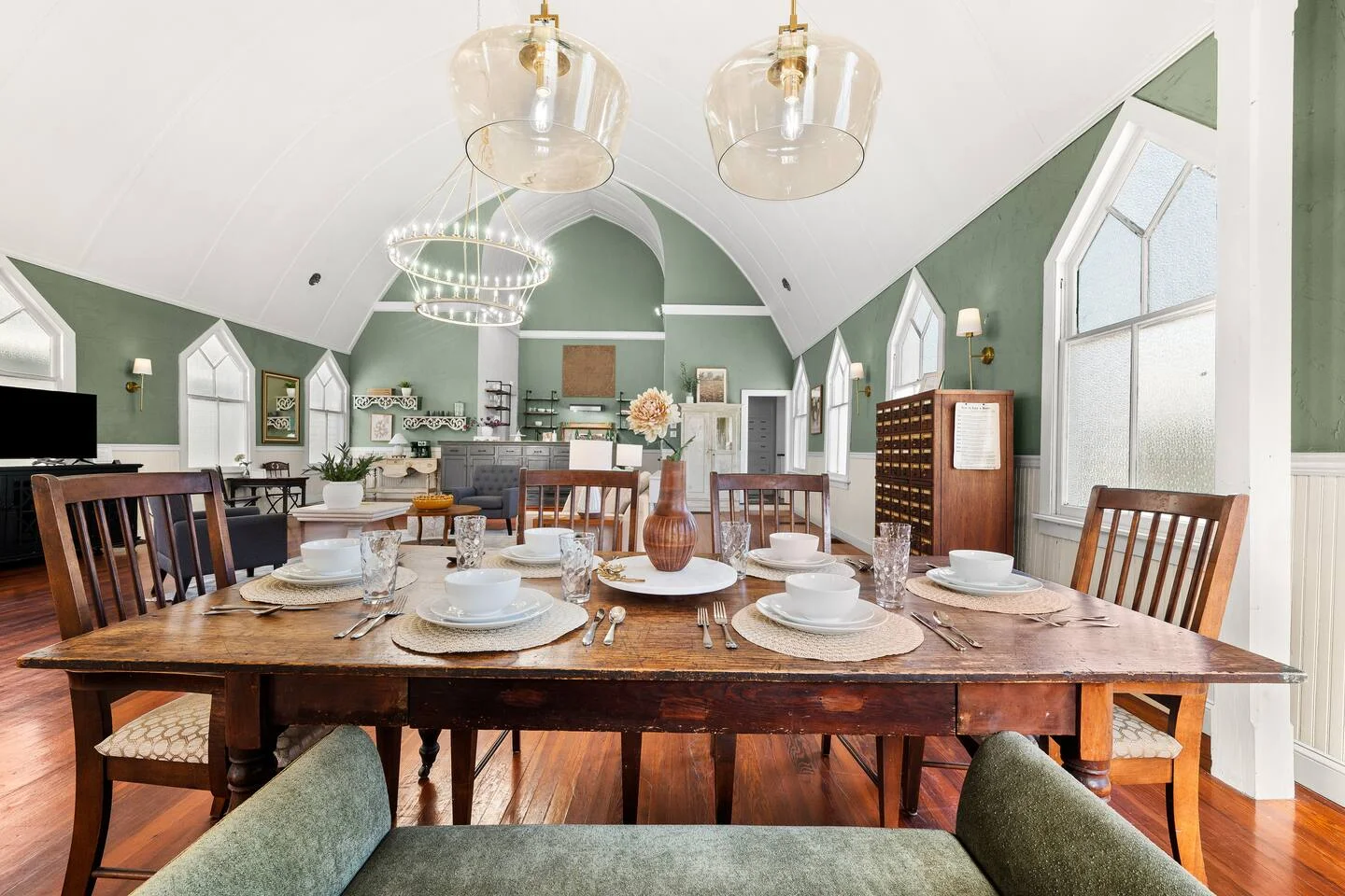 Elegant dining room in historic St. Augustine church conversion with vaulted ceilings and sage green walls