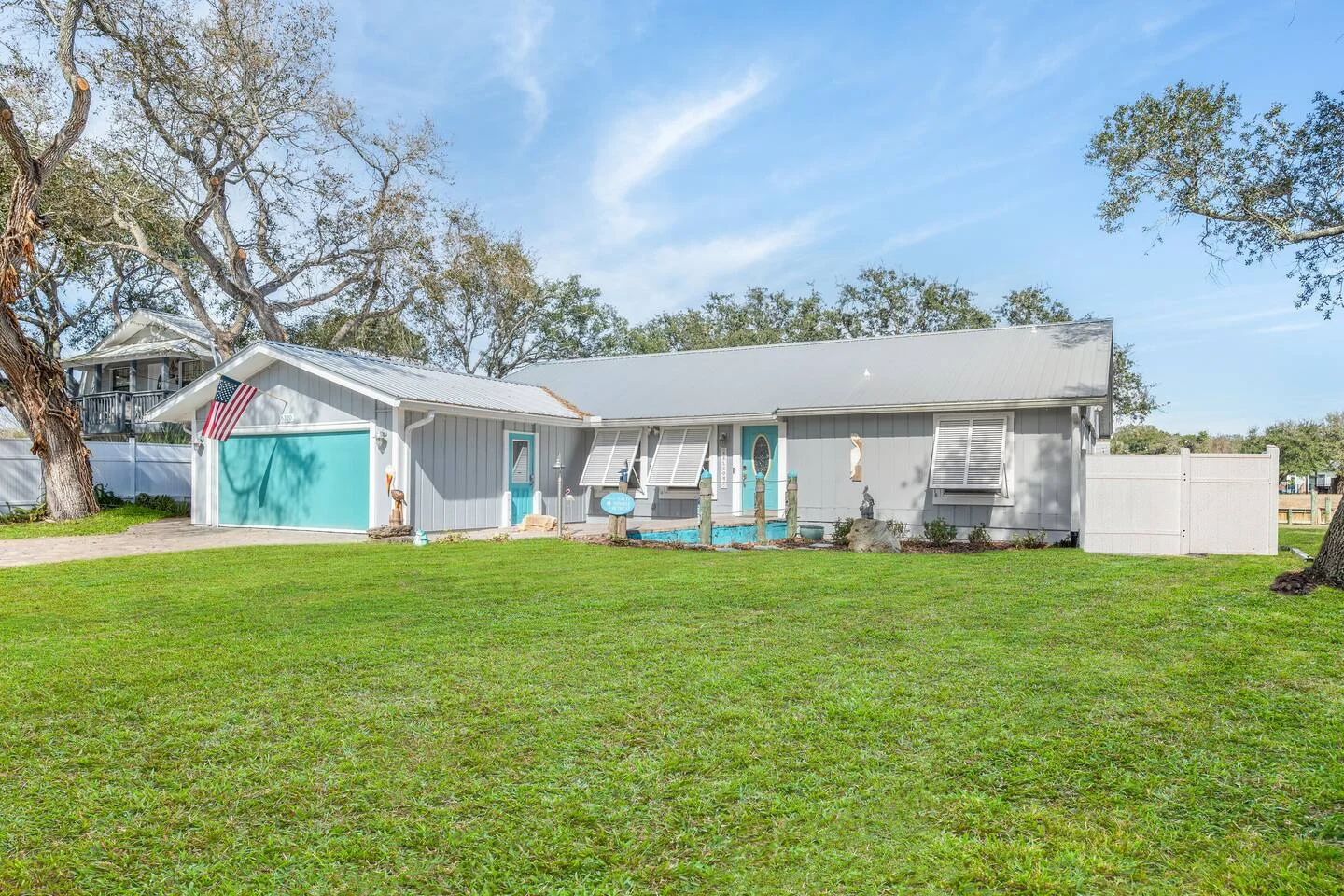 Charming St. Augustine beachside cottage with turquoise door and white siding showing property management considerations for