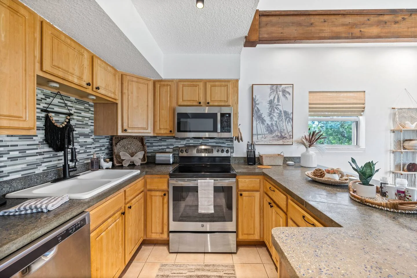Modern St. Augustine vacation rental kitchen with wood cabinetry, granite countertops, and stainless steel appliances