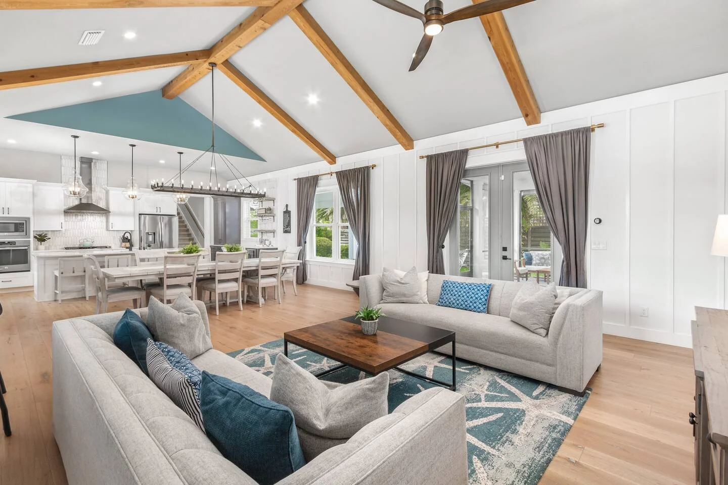 Modern open-concept living room with vaulted ceilings and wood beams in St. Augustine FL property