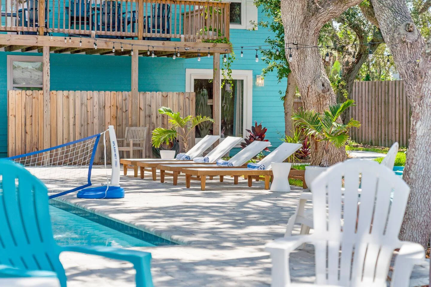 Professional co-hosting vacation rental pool area at turquoise beachside property with lounge chairs and tropical