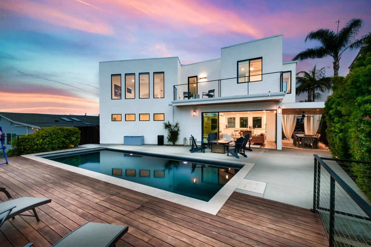 Modern luxury home exterior in San Diego with illuminated pool and contemporary architecture ideal for Airbnb property
