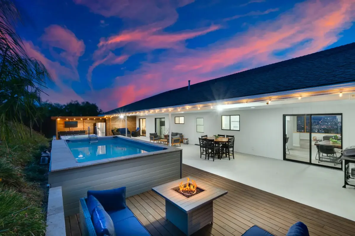 Luxury backyard pool with fire pit lounge area and modern home, perfect for downtown San Diego rooftop rental properties