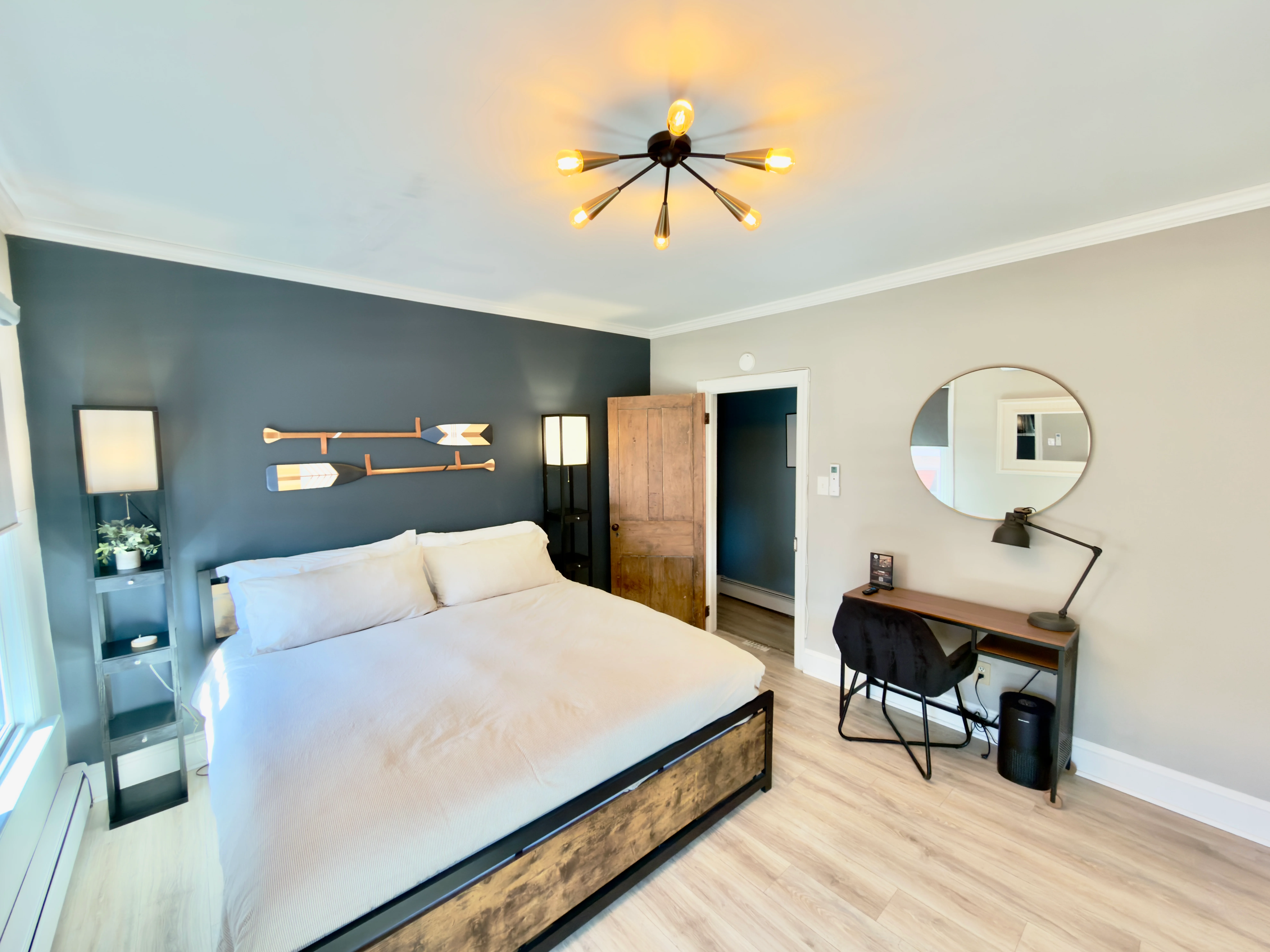 Modern coastal bedroom with queen bed, teal accent wall, and nautical decor at Cape Oar in Cape May