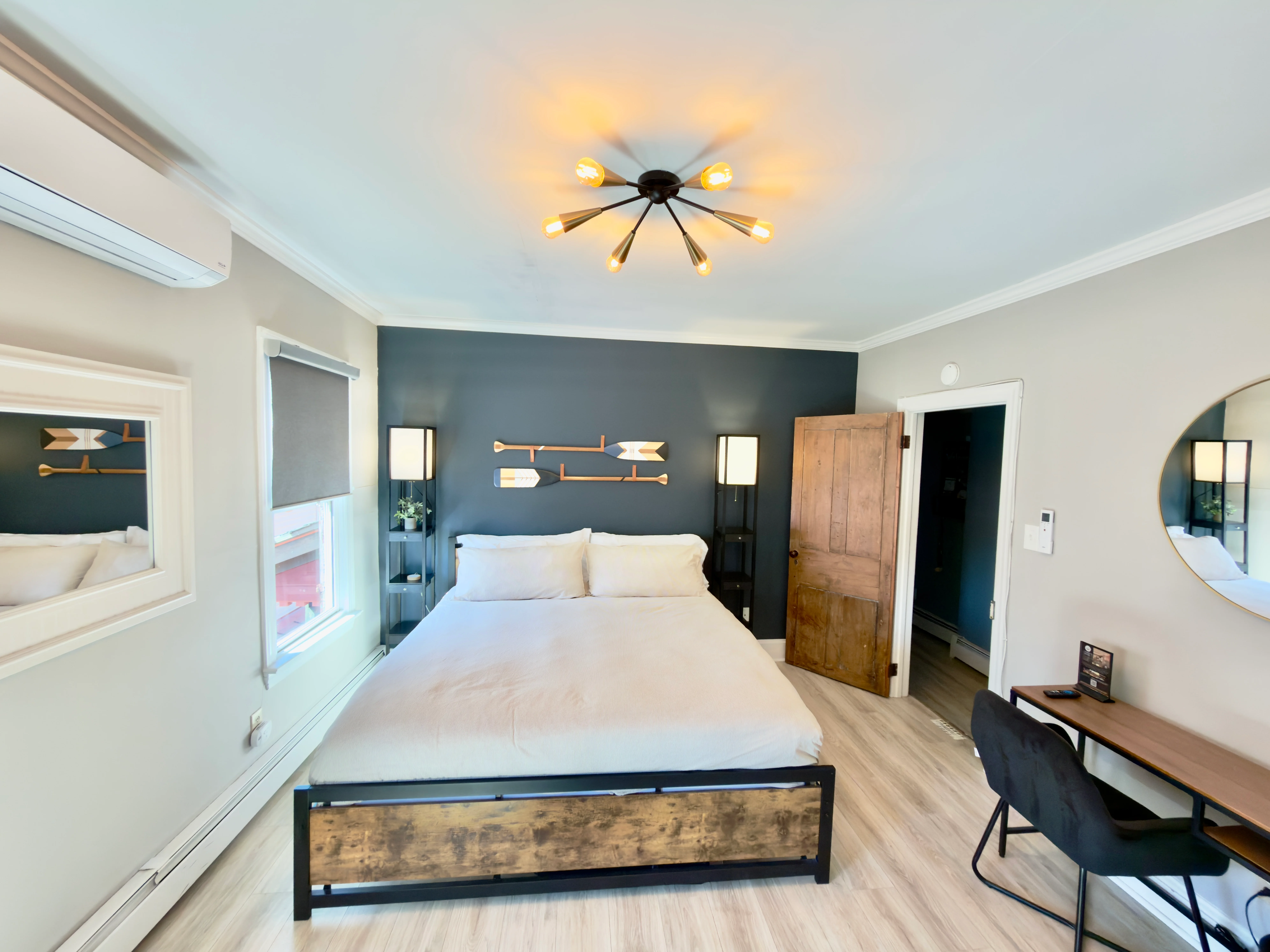 Modern coastal bedroom with queen bed, teal accent wall, and nautical decor in a Cape May NJ neighborhood vacation rental
