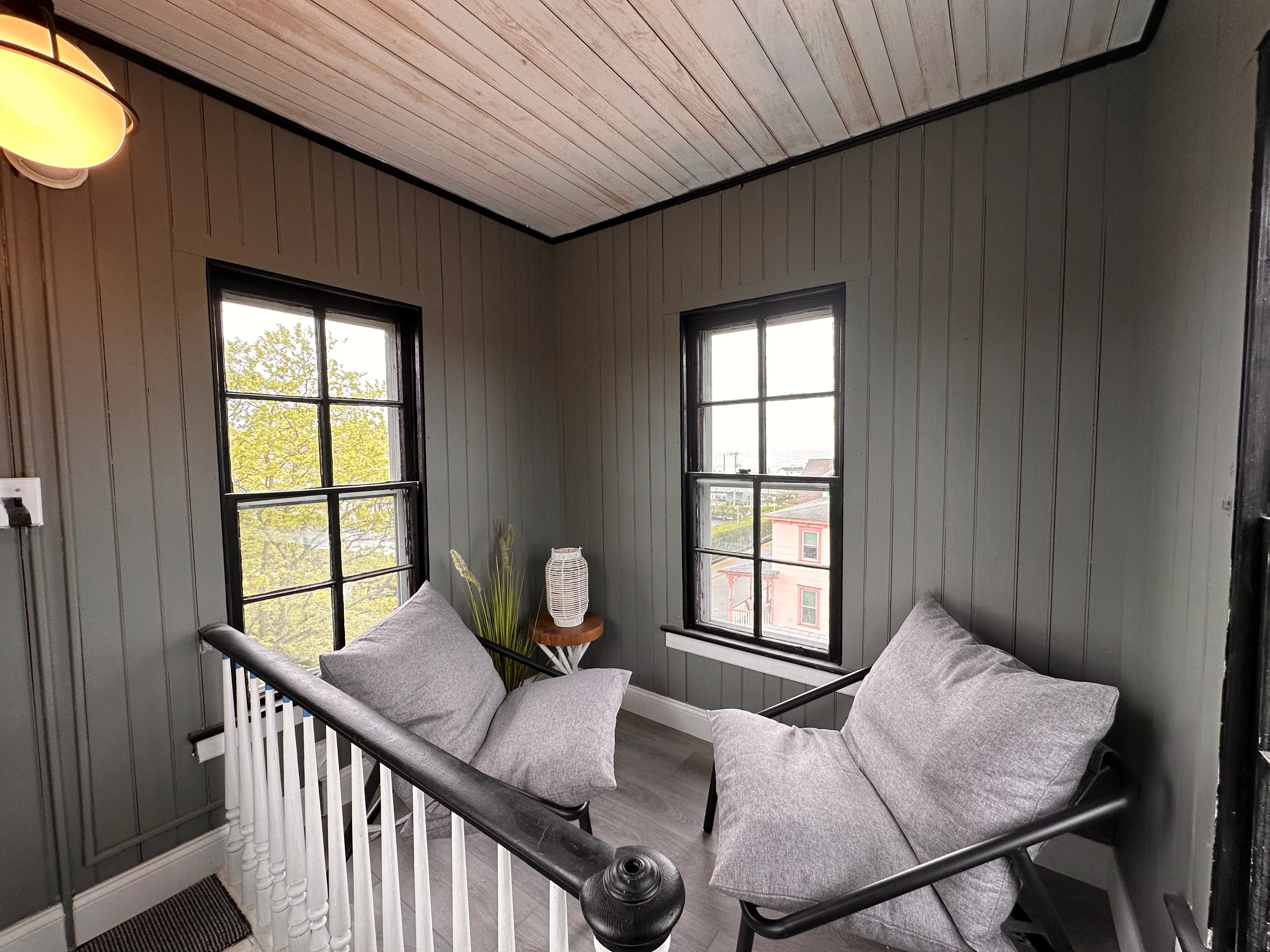 Modern loft bedroom with daybed and black-framed windows at Cape Belvedere in Cape May
