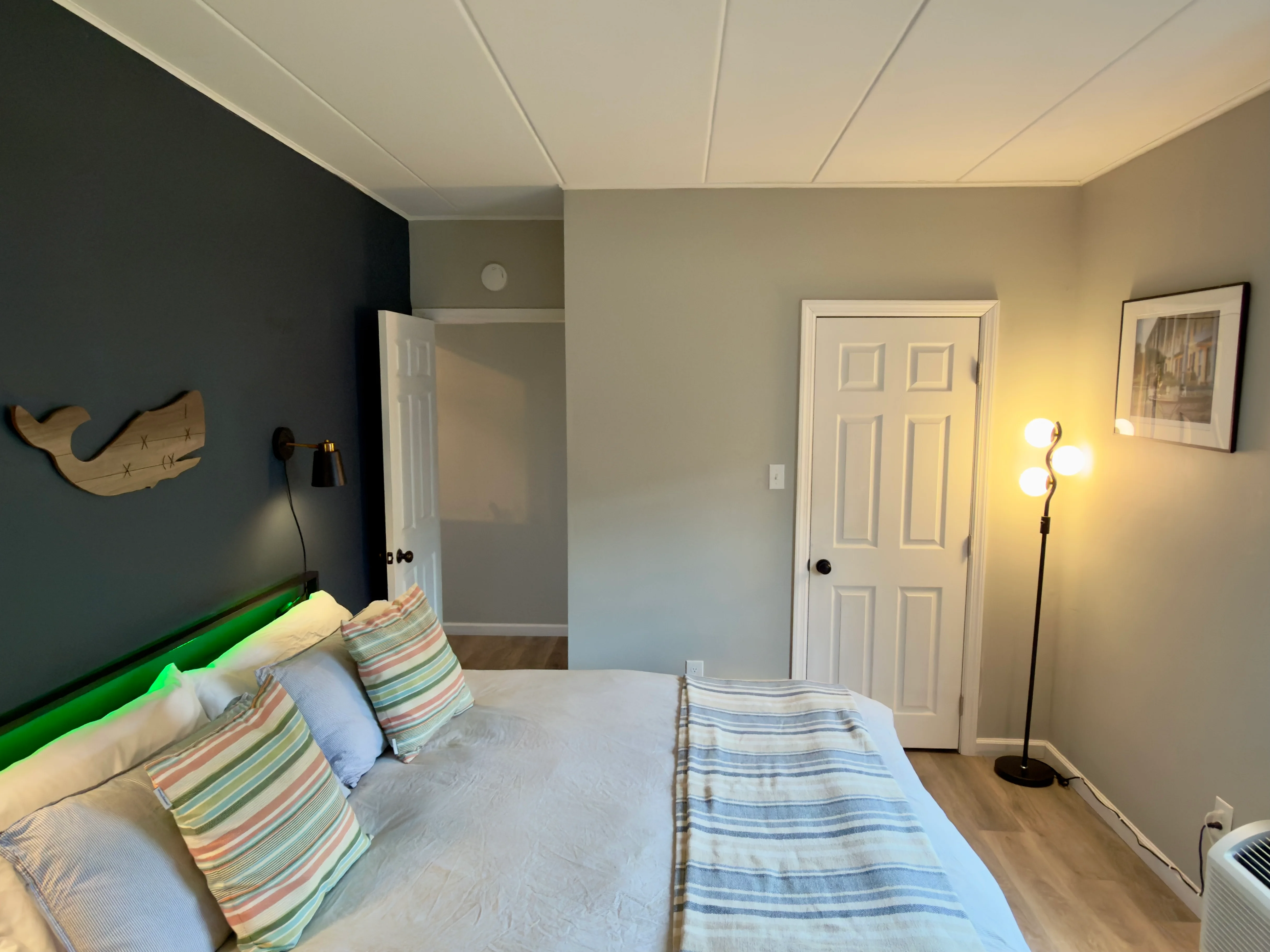 Nautical-themed bedroom in Cape May Historic District accommodations with green bed frame and whale wall art