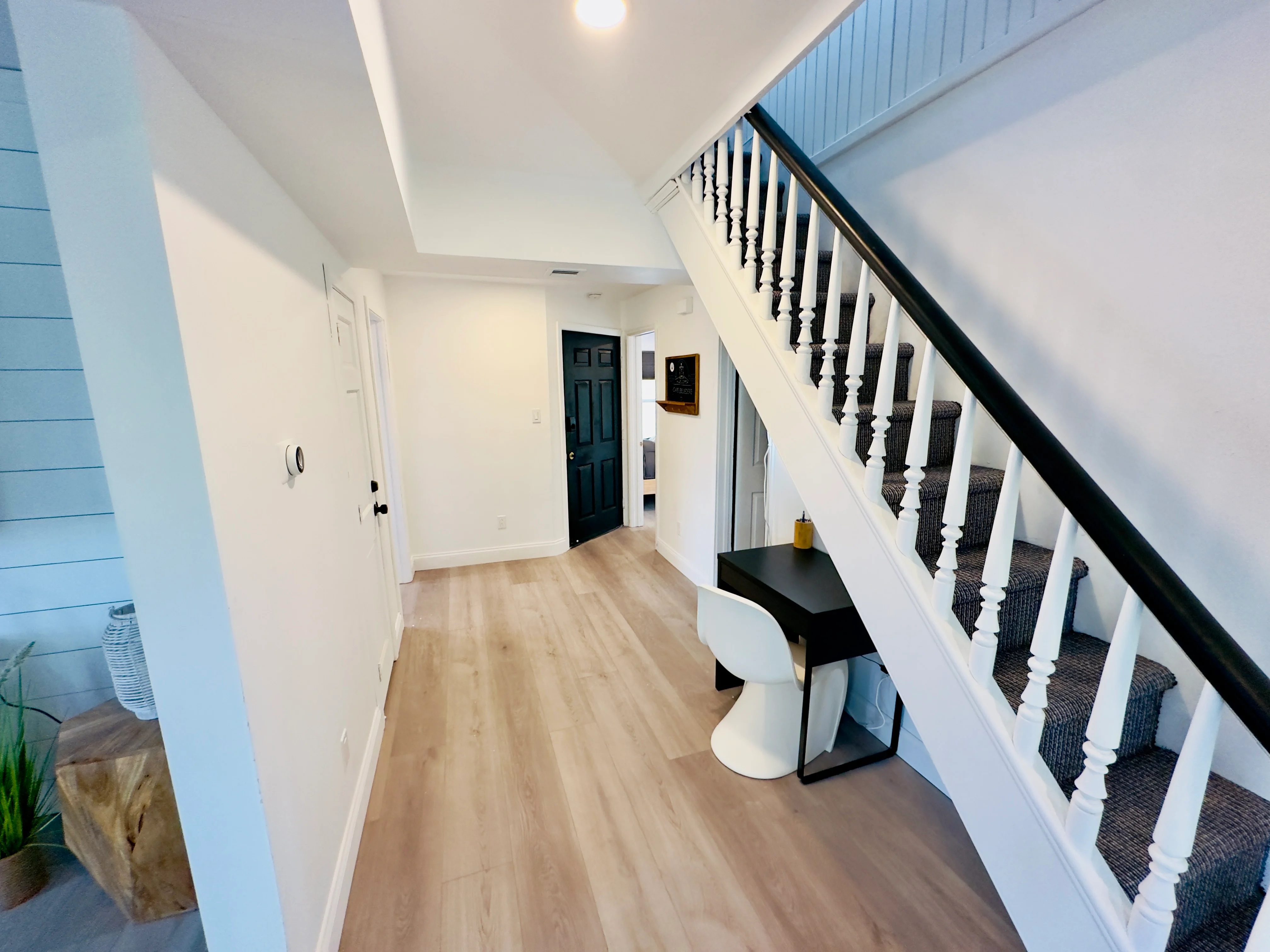 Modern entryway with black and white staircase in Cape Belvedere fine dining property
