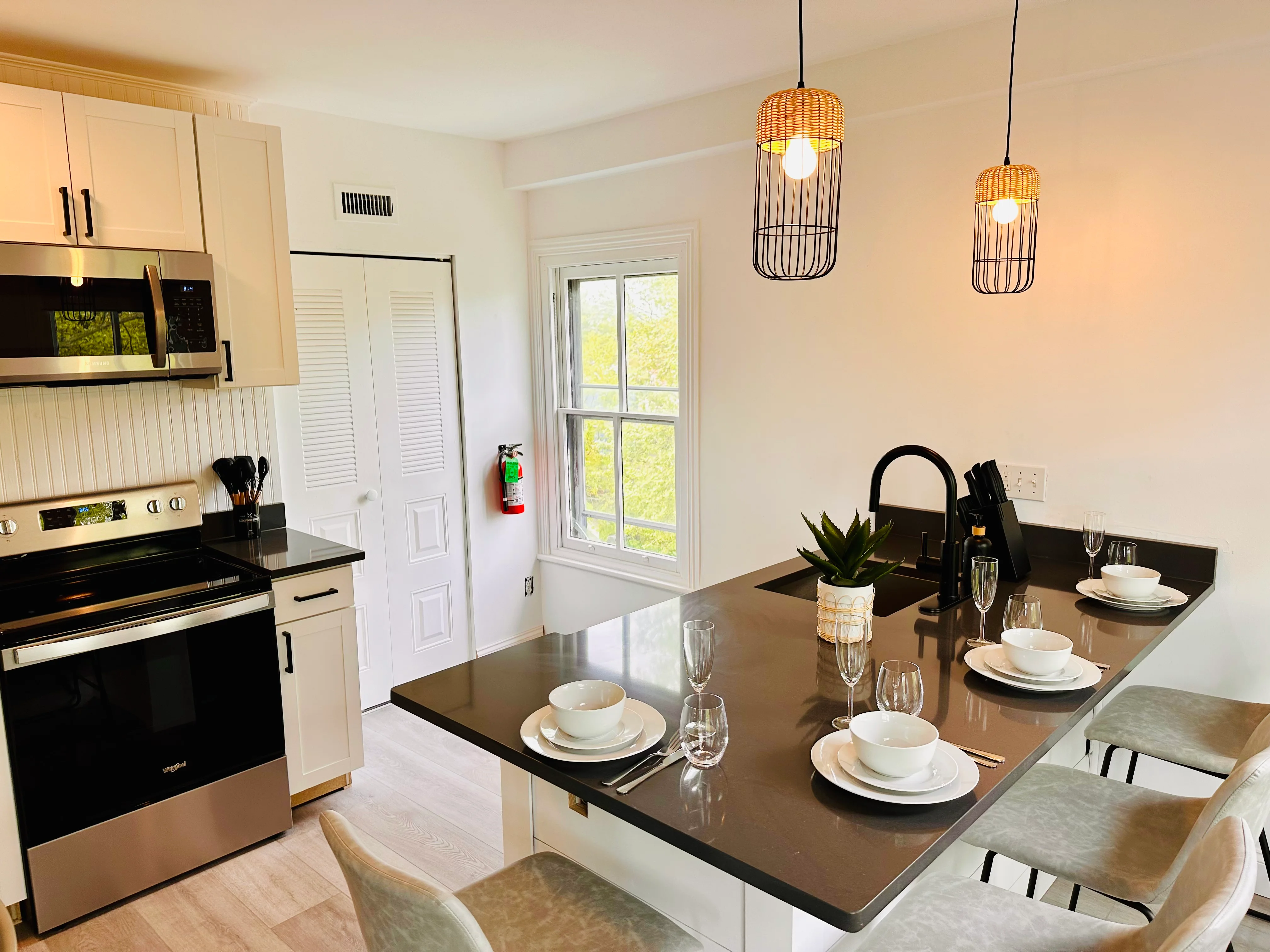 Modern open-concept kitchen and dining area with black countertops and stainless steel appliances at Cape Belvedere in Cape