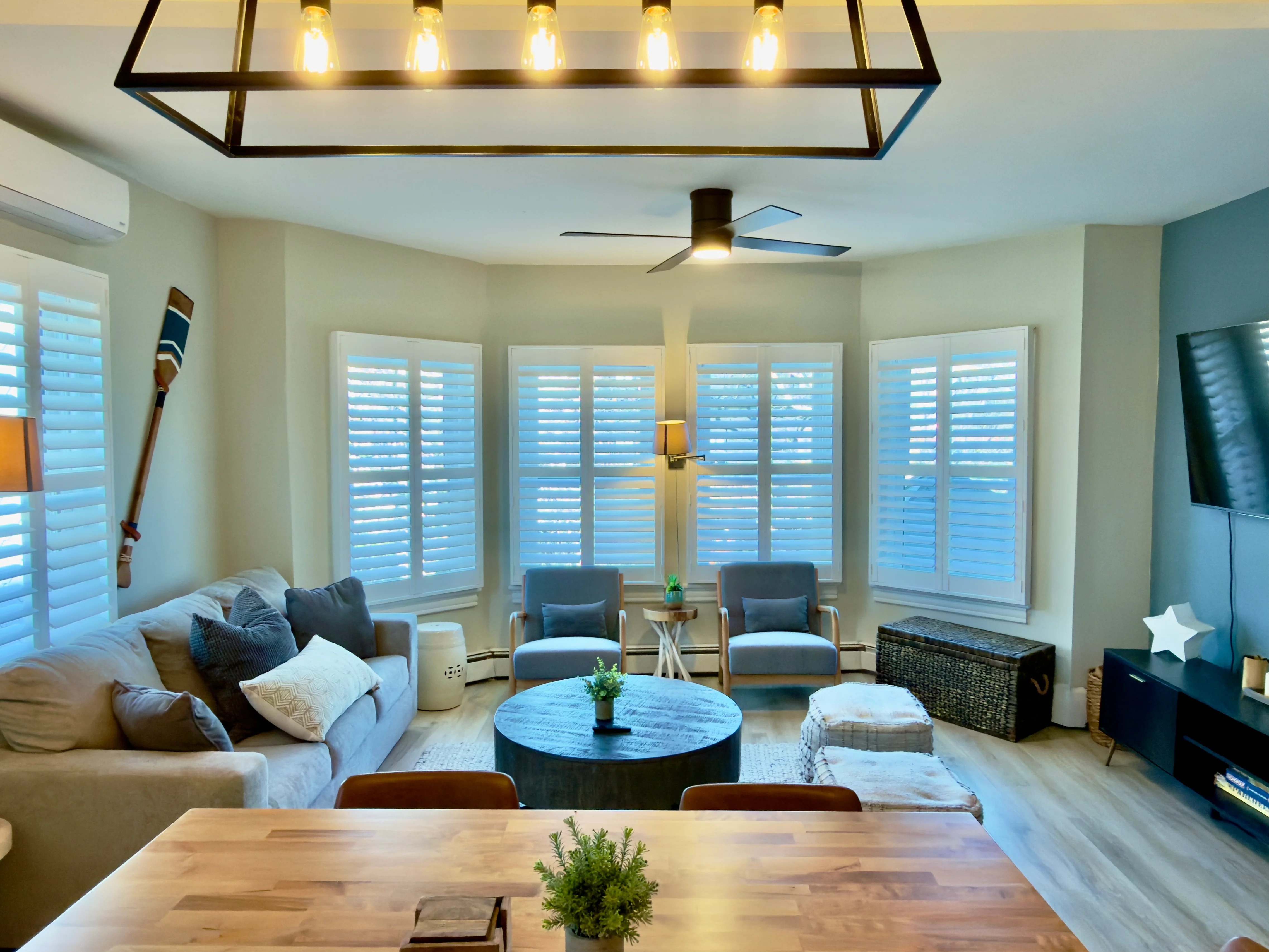 Bright living room with ocean views through plantation shutters overlooking Cape May beach, featuring coastal-inspired decor