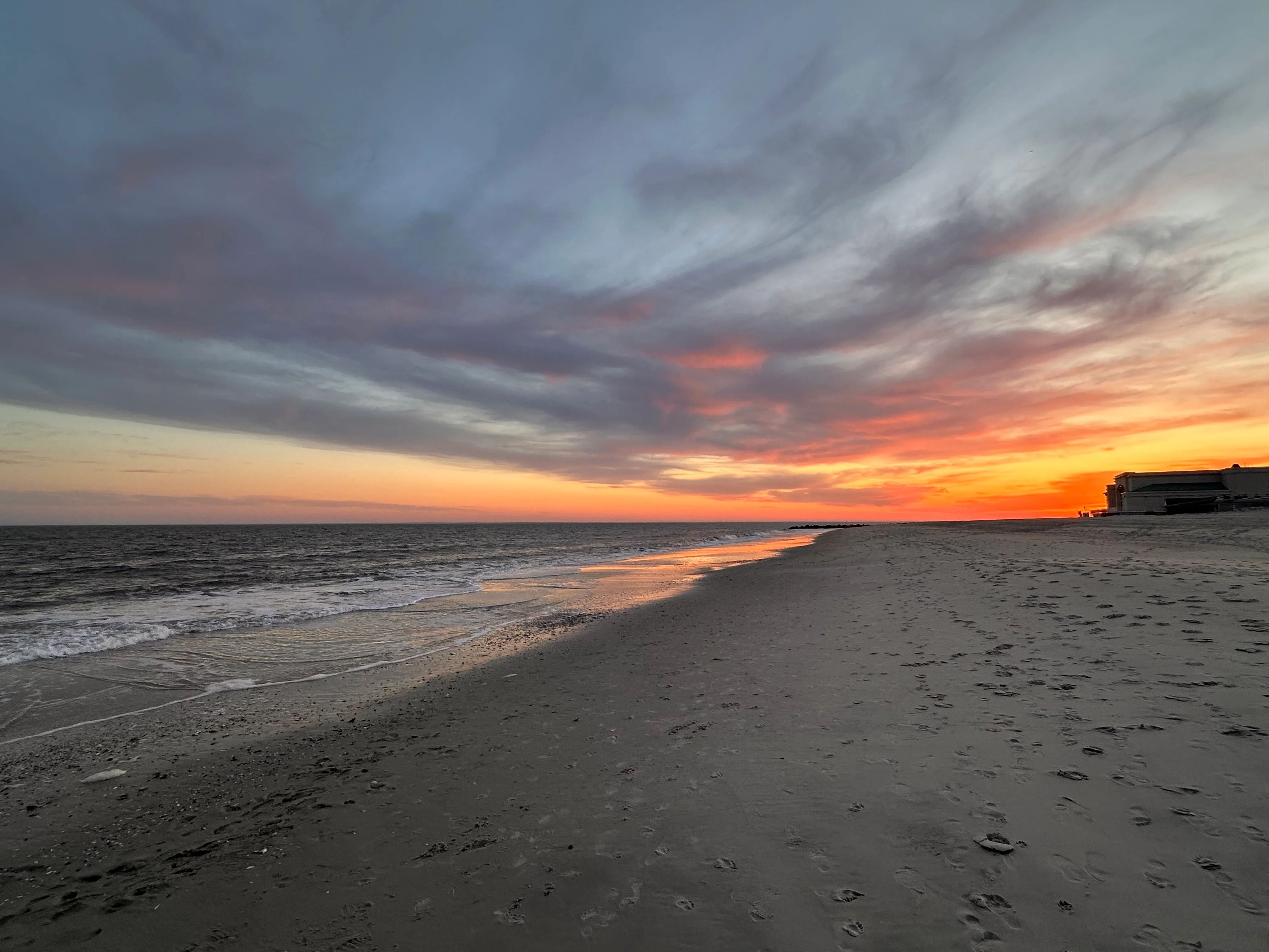 Cape May beach waterfront at golden hour with ocean waves and sandy shoreline