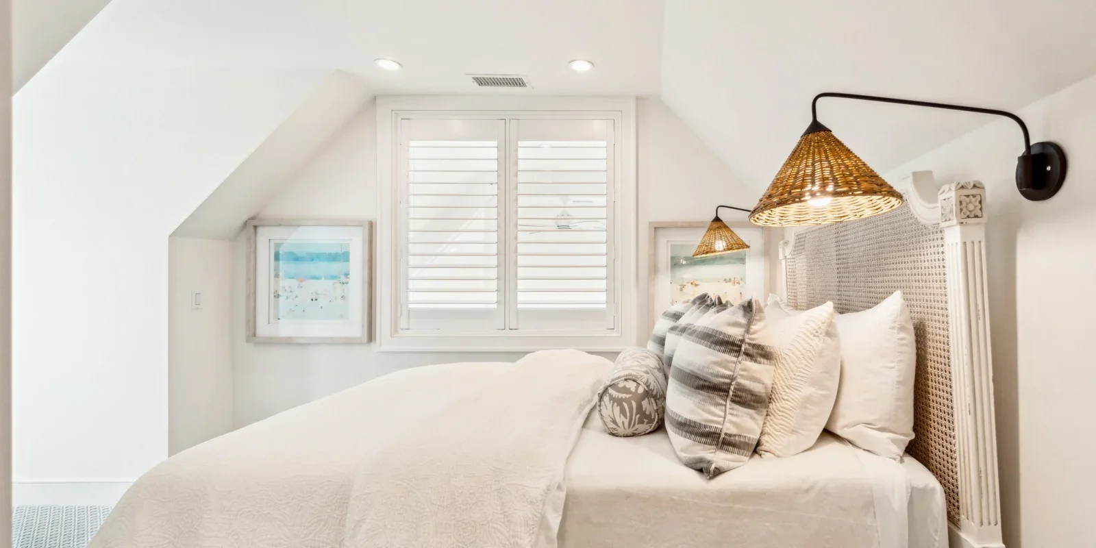 Coastal bedroom with woven rattan headboard and neutral bedding at The Ocean Blue at Seascape near Charleston SC