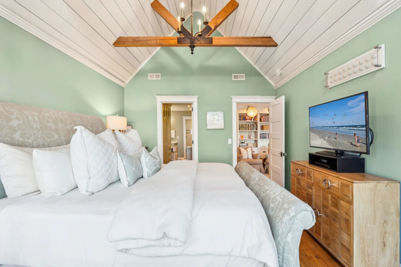 Coastal master bedroom with mint-green walls, vaulted ceiling, and beach-themed decor at Kiawah Island