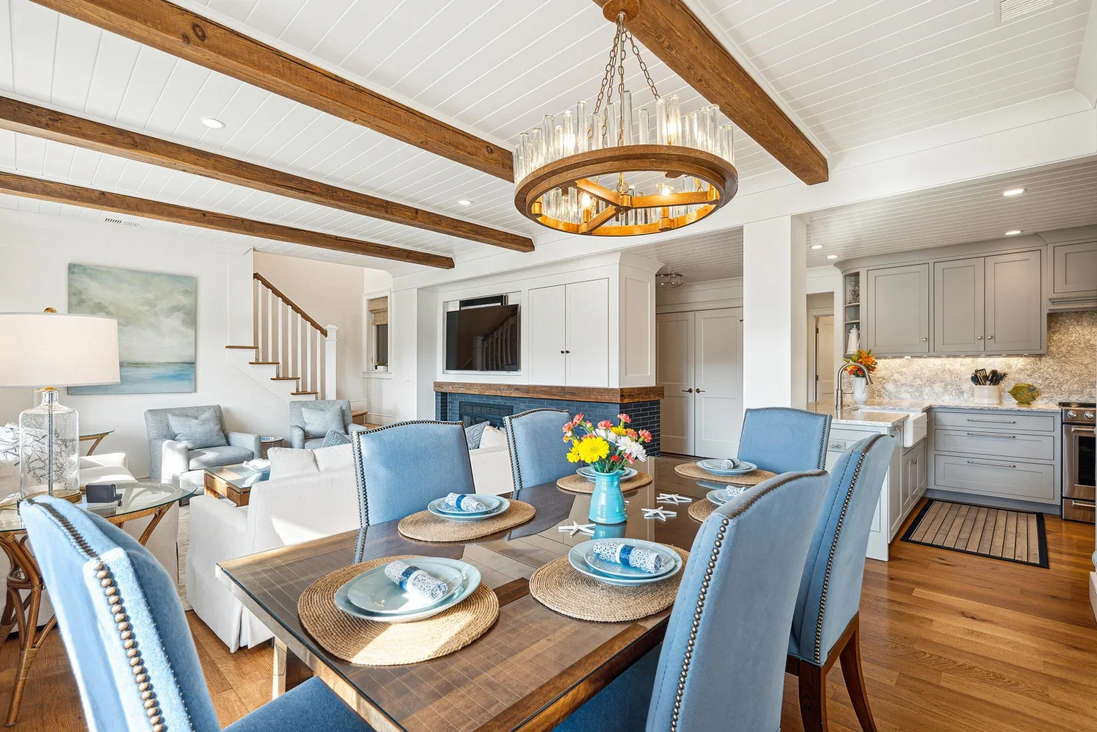 Luxury villa dining room with coastal design and blue chairs overlooking open concept kitchen at Kiawah Island