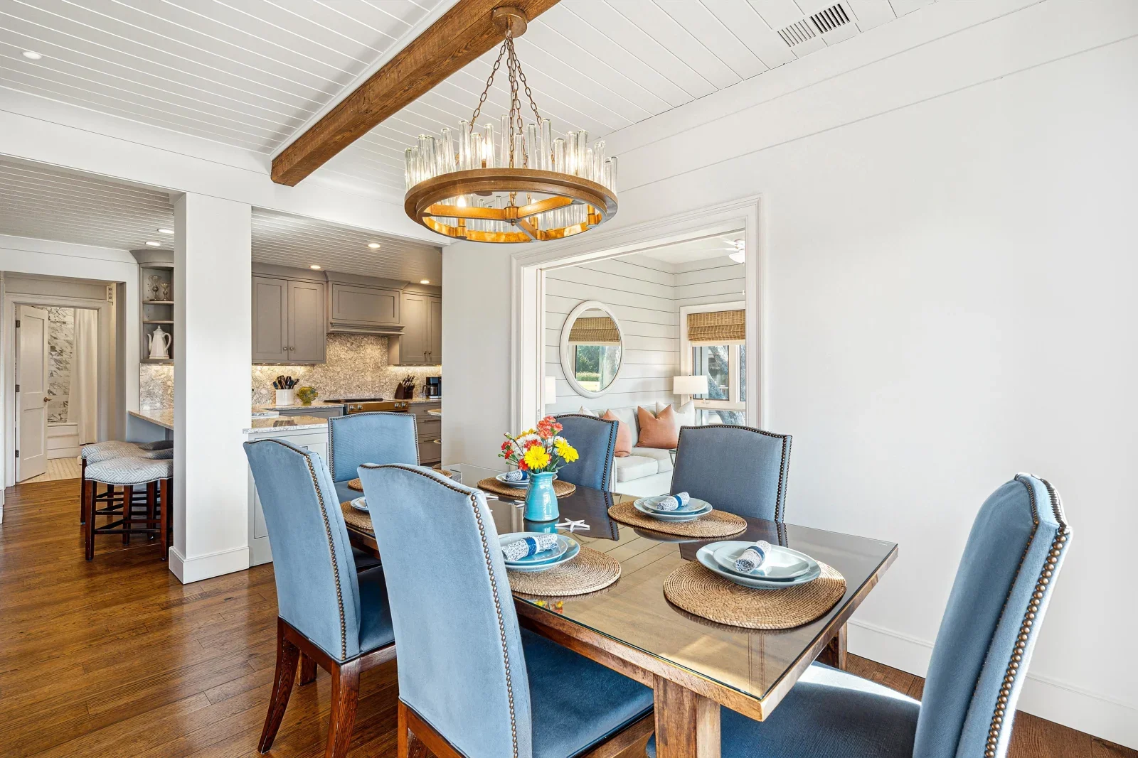 Elegant beach house dining room with blue upholstered chairs and ocean-view kitchen at Kiawah Island luxury rental