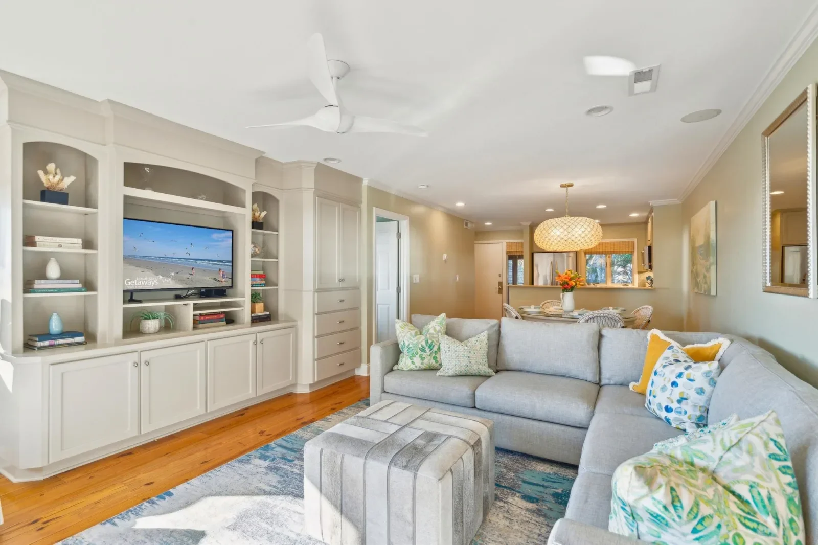 Modern living room with gray sectional and ocean view balcony access in Kiawah Island oceanfront rental