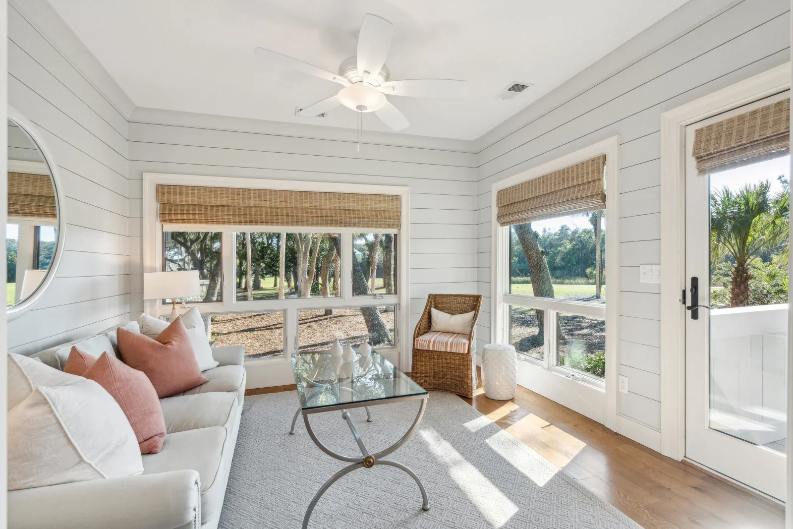 Coastal living room with white shiplap walls, large windows, and cream sofa at Kiawah Island property