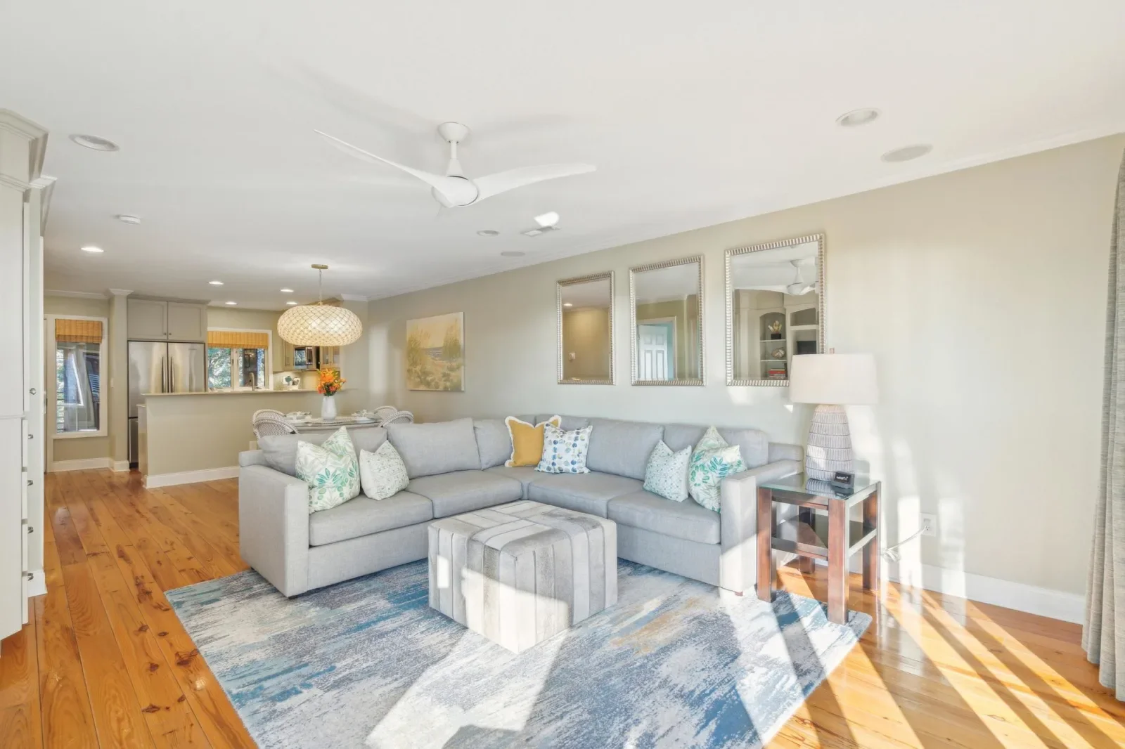 Gray sectional sofa and modern kitchen in open-concept Kiawah Island vacation rental living room