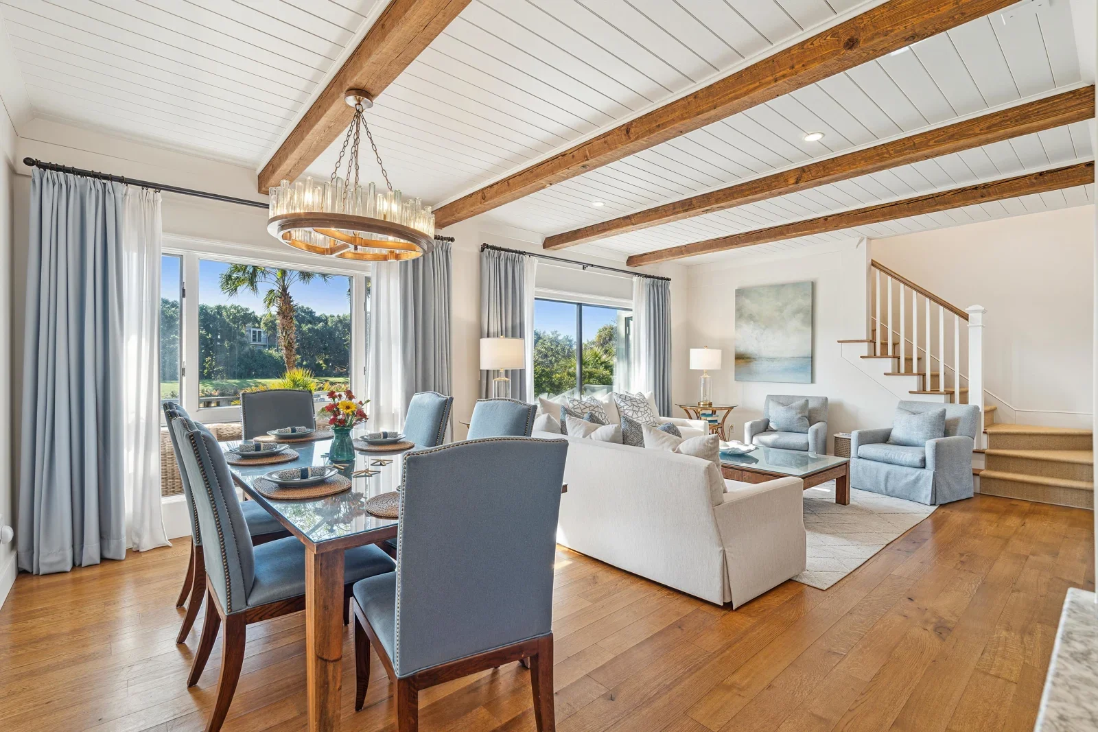 Open-concept living and dining room with exposed beams and golf course views at Turtle Point on Kiawah Island