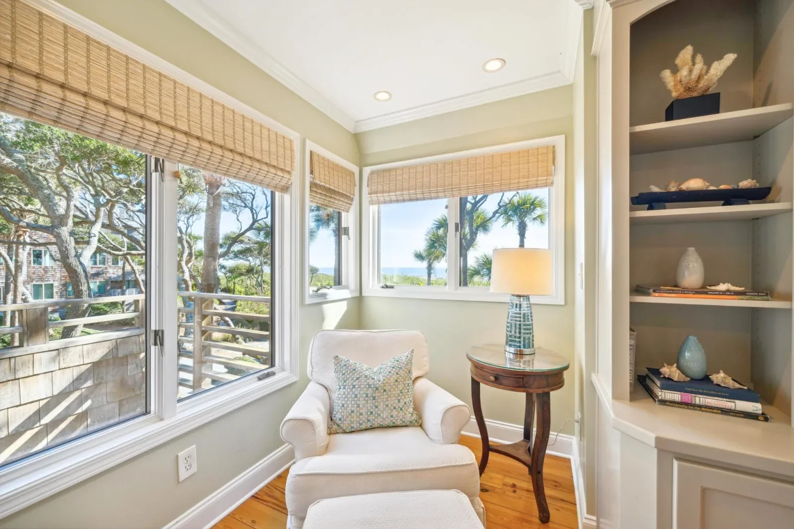 Coastal retreat reading nook with cream armchair and ocean views at Kiawah Island Getaways
