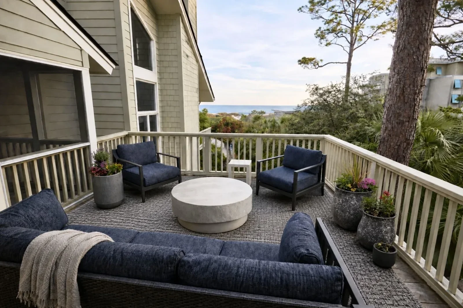 Elevated oceanfront deck with blue seating and fire pit at a Kiawah Island house rental with panoramic Atlantic views