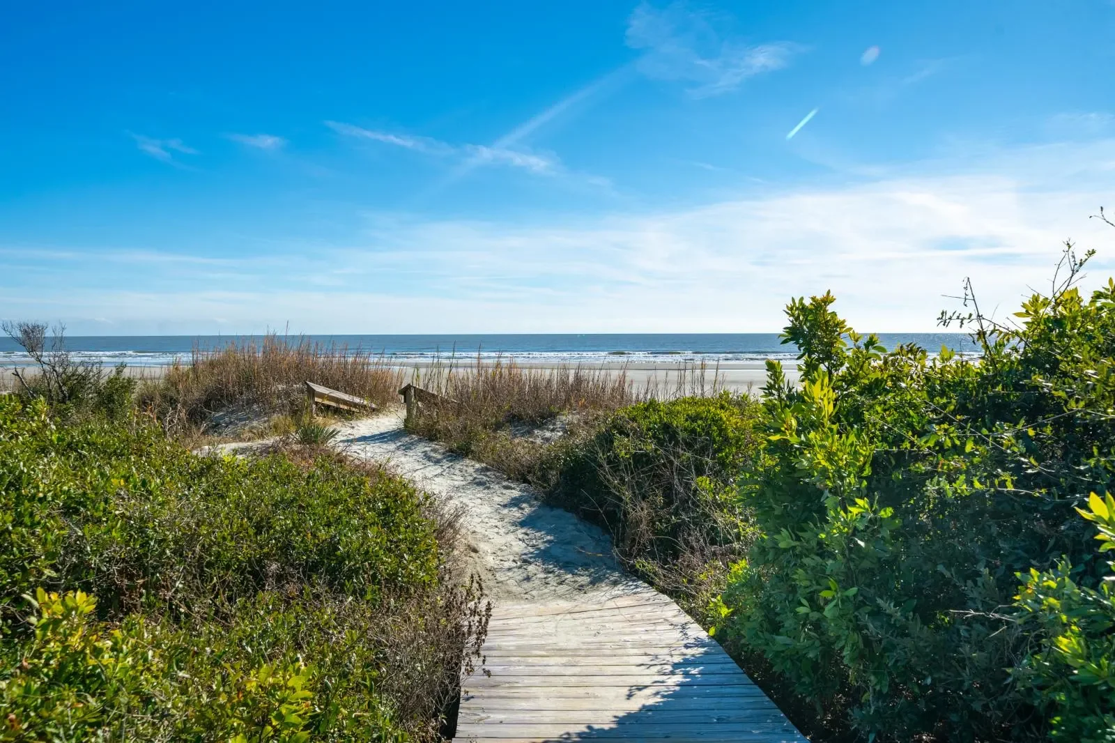 Wooden boardwalk through dune grasses leading to sandy beach and ocean at Kiawah Island vacation rental