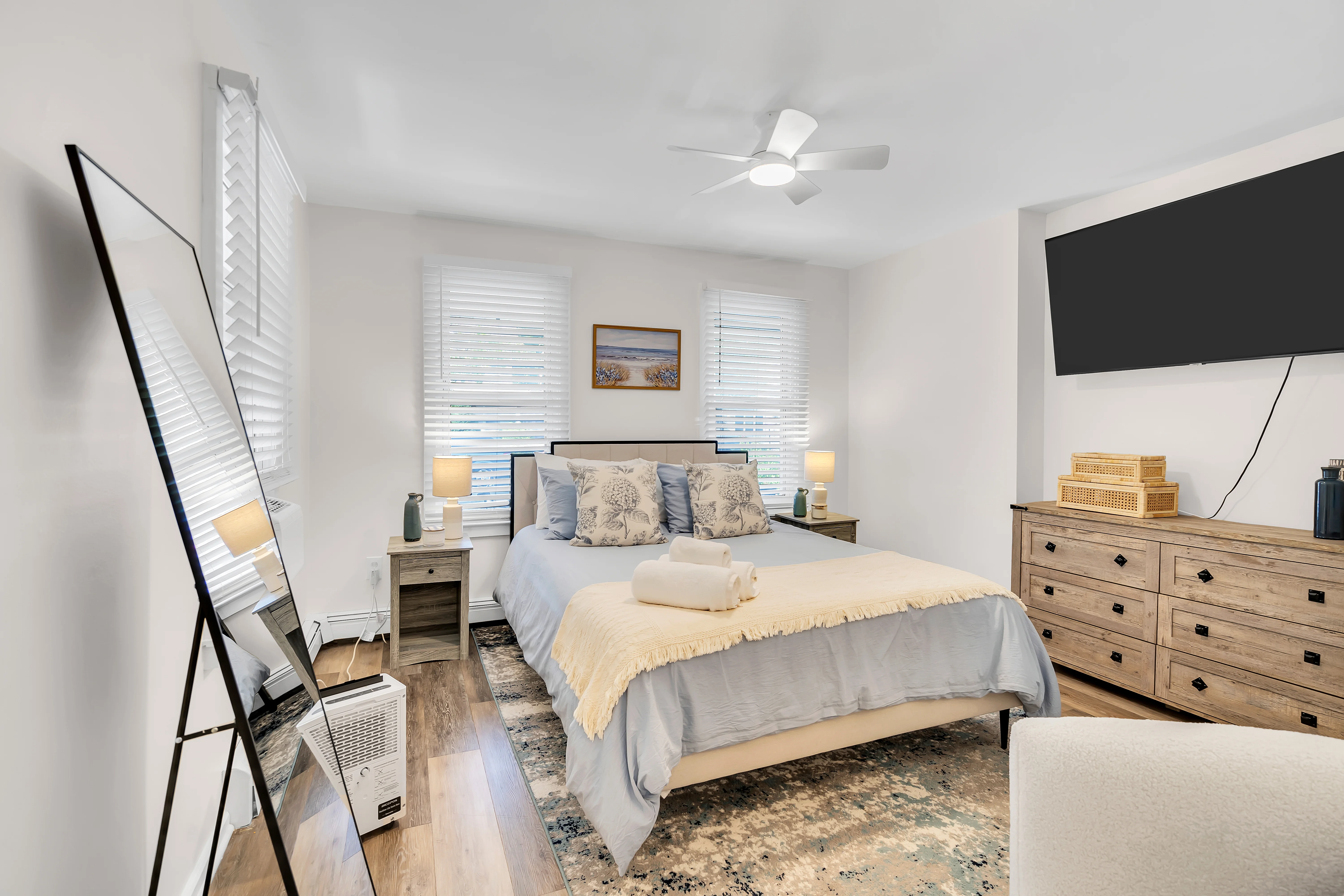 Coastal master bedroom with professional turnover service setup featuring blue and cream linens in Ocean Grove, NJ vacation