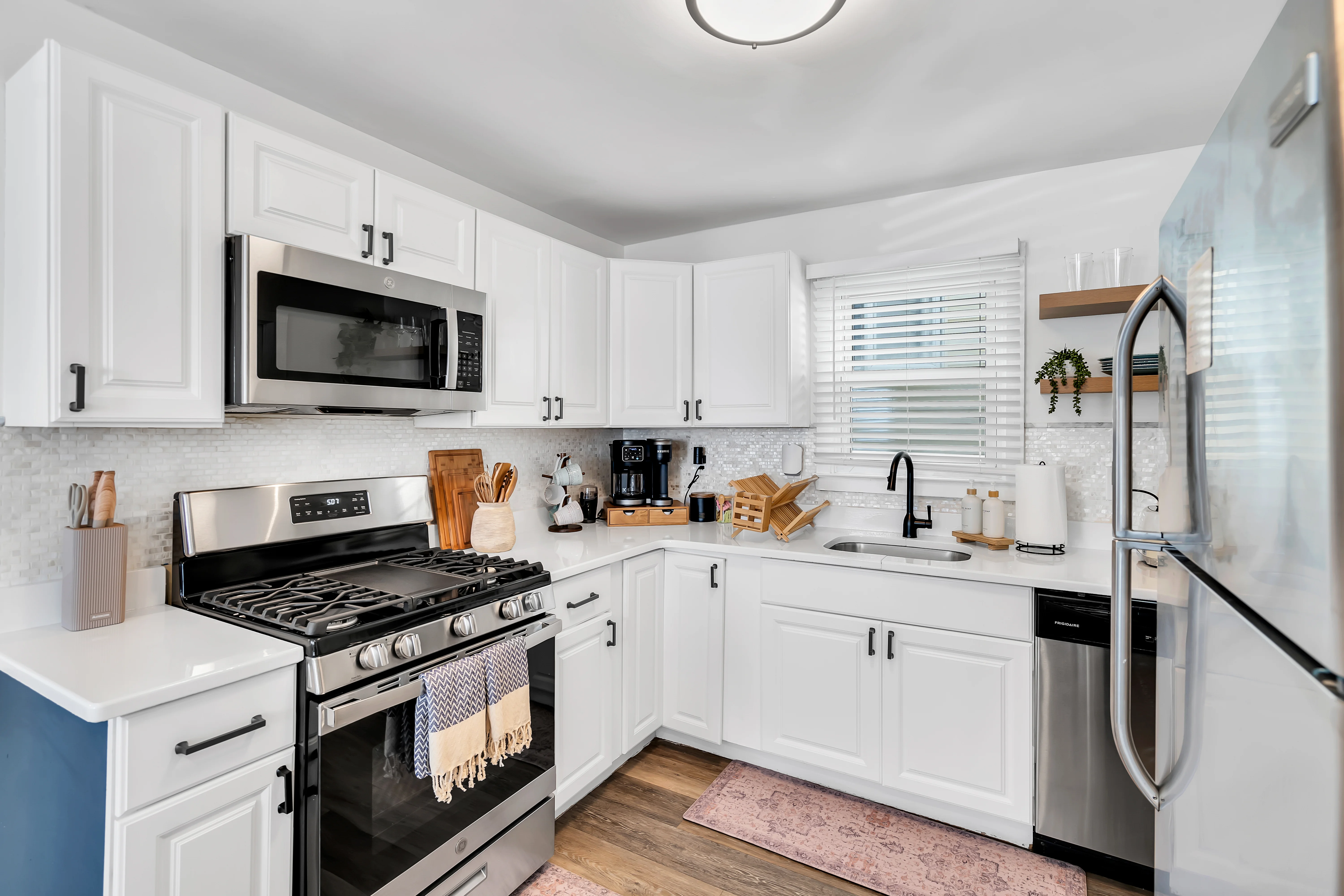Modern kitchen with white cabinets, stainless steel appliances, marble backsplash in an Ocean Grove, NJ Airbnb managed by Endless Stays