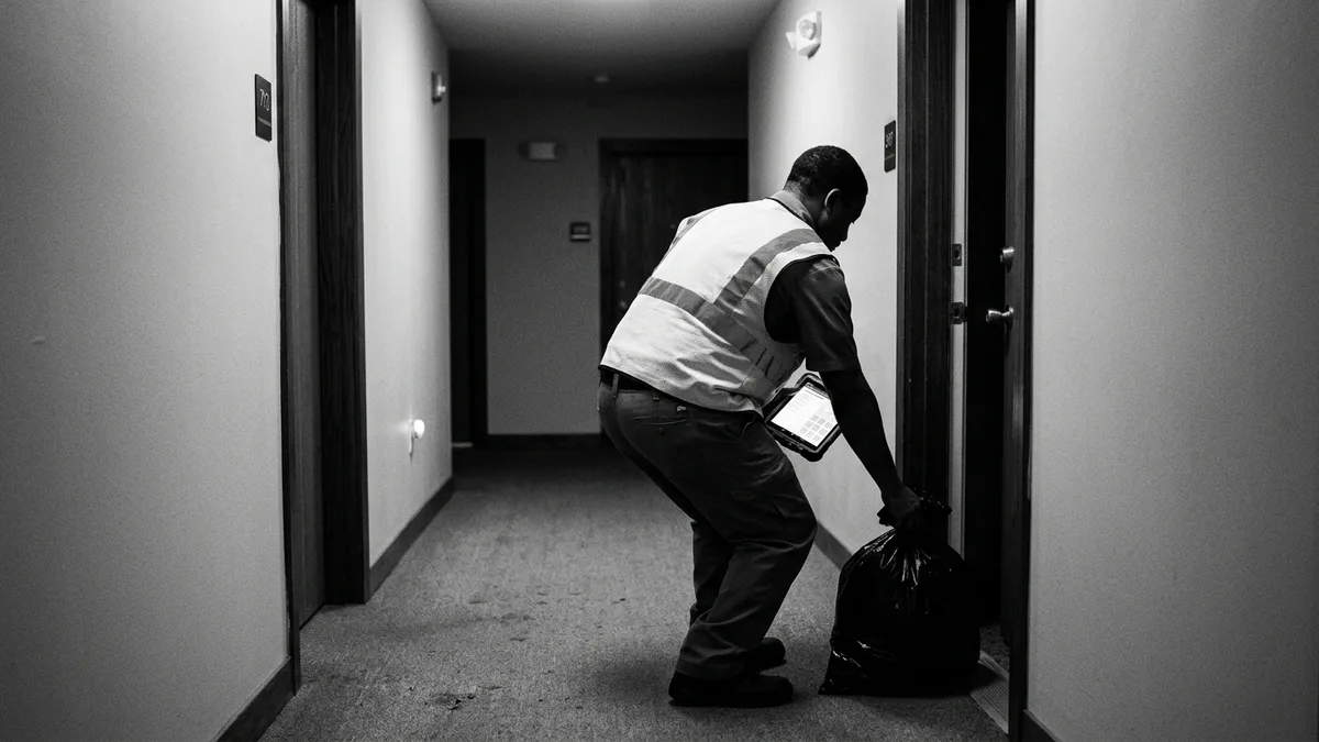 Lowcountry valet trash crew collecting bagged waste at an apartment door at night, photo-verified