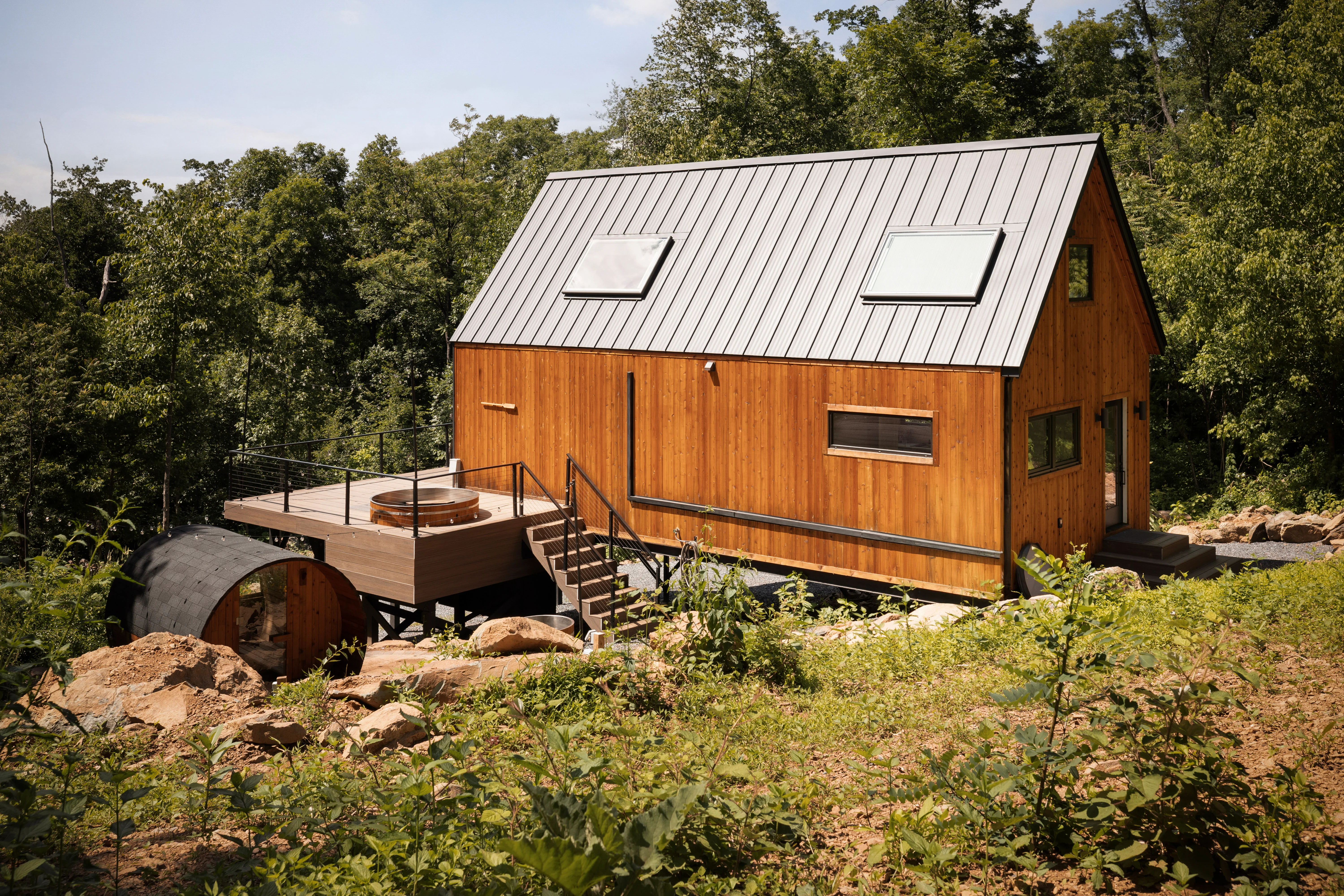 Modern wooden cabin with metal roof and hot tub on forest deck in Shenandoah Valley
