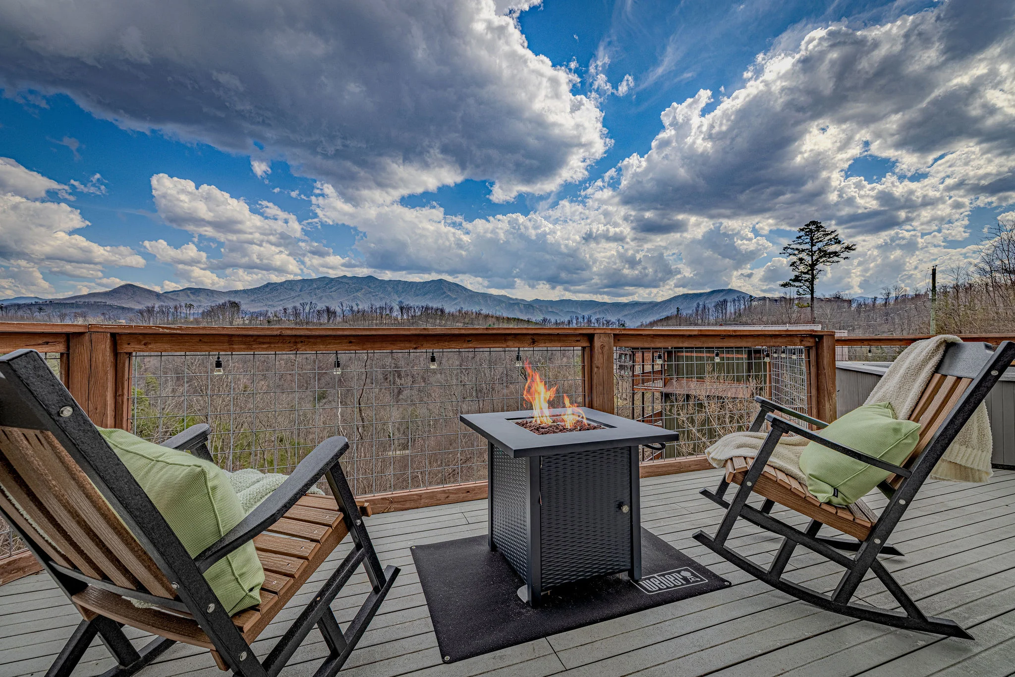 Private cabin deck with fire pit, lounge chairs, and mountain views in Gatlinburg
