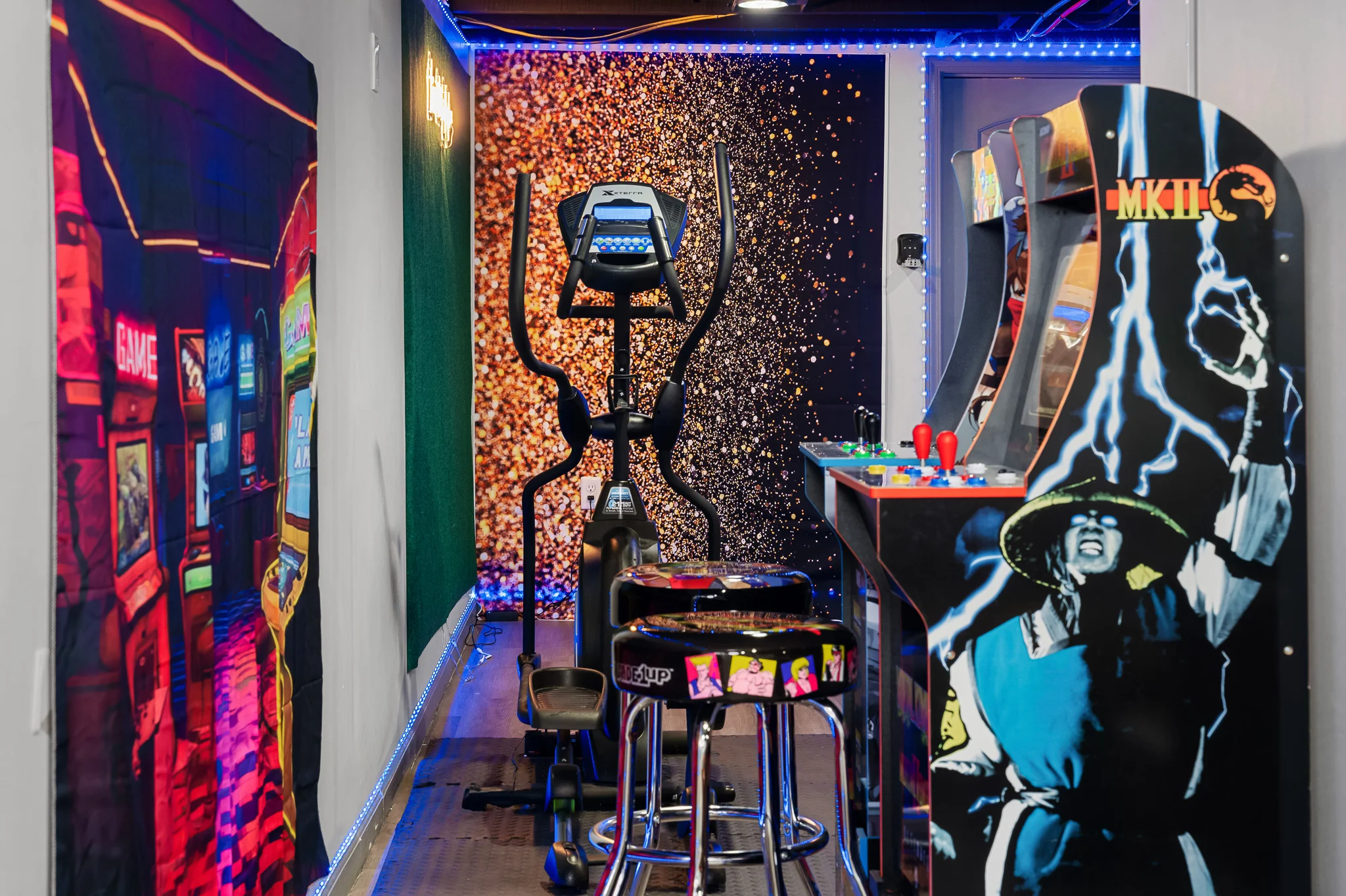 Colorful arcade machines with neon lighting in family vacation rental game room for rainy days in Louisville