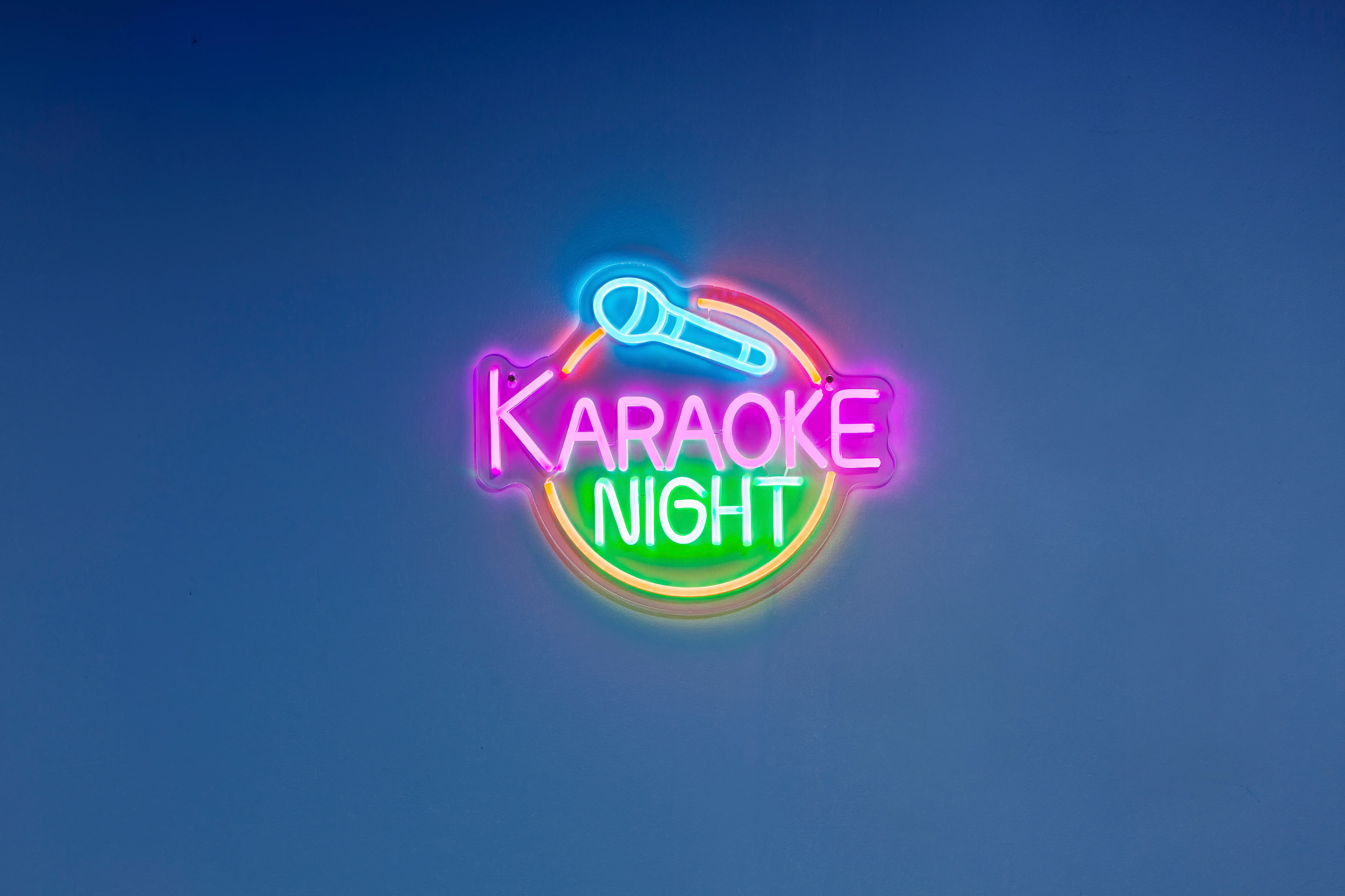 Colorful neon karaoke sign with microphone icon at Glencairn Knoll vacation rental entertainment space in Louisville