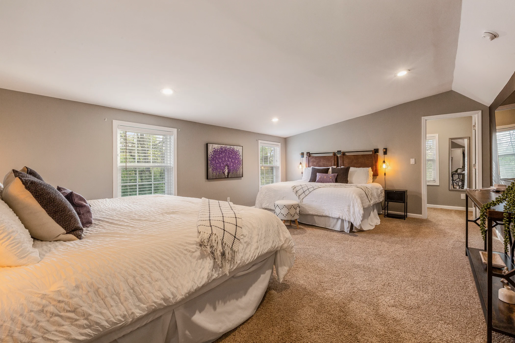 Master bedroom suite with two queen beds, neutral bedding, and shutter-framed windows at Glencairn Knoll, a family-friendly