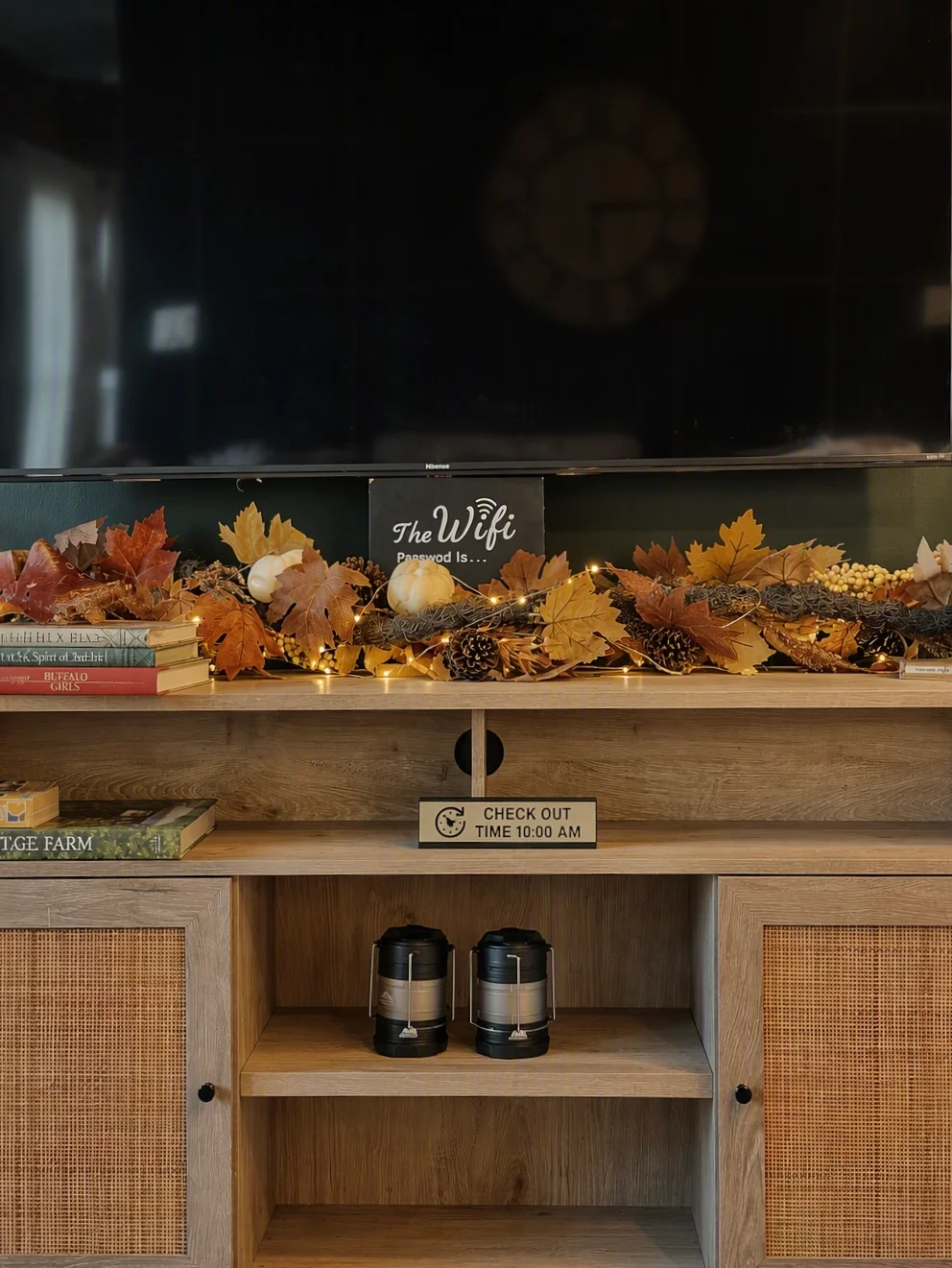 Entryway console with fall leaves, pumpkins, and string lights, WiFi password sign, and coffee makers at Glencairn Knoll in