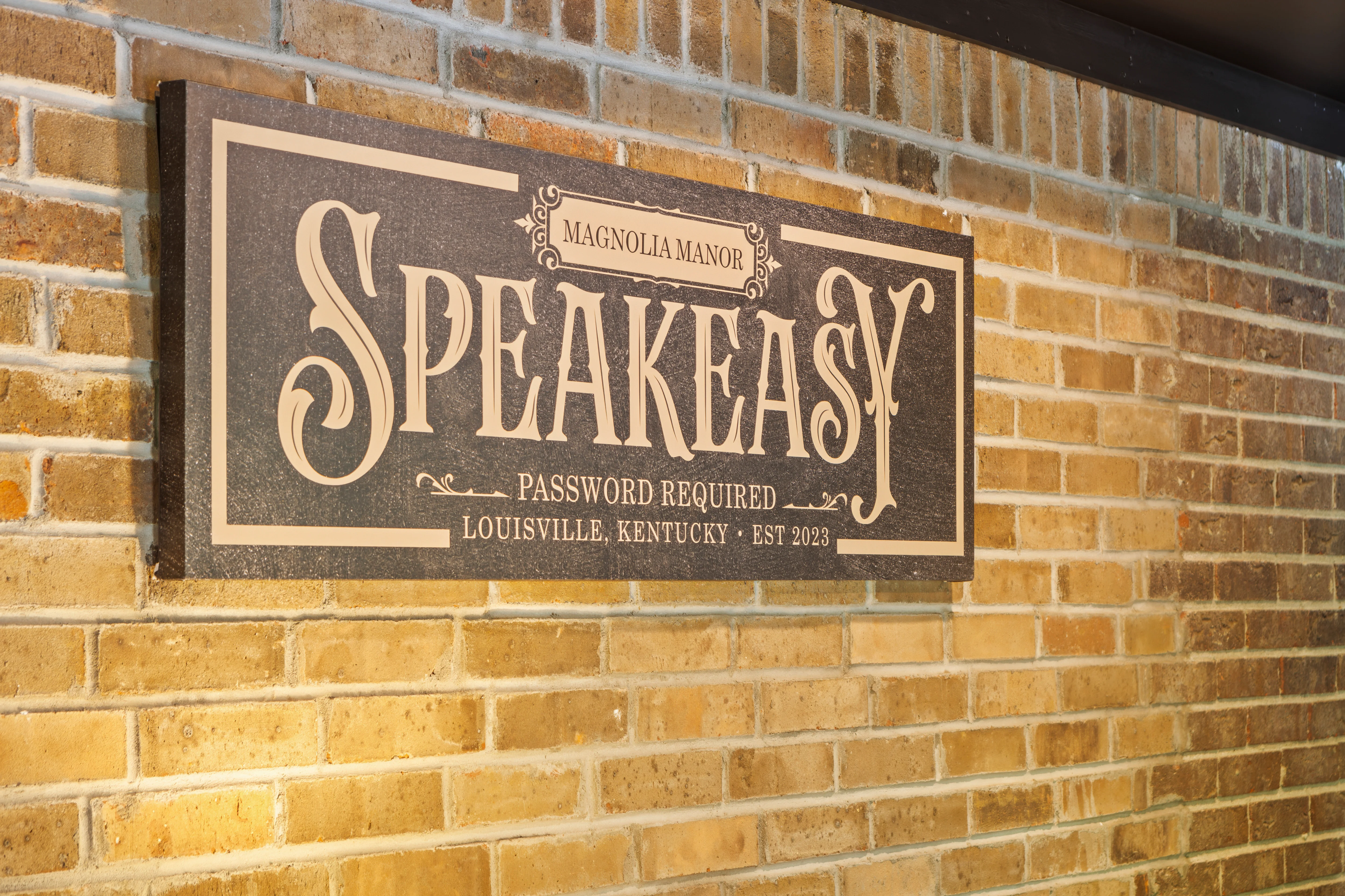 Ornate wooden Speakeasy sign on brick wall at Magnolia Manor entrance, a live music spot to visit tonight in Louisville KY,