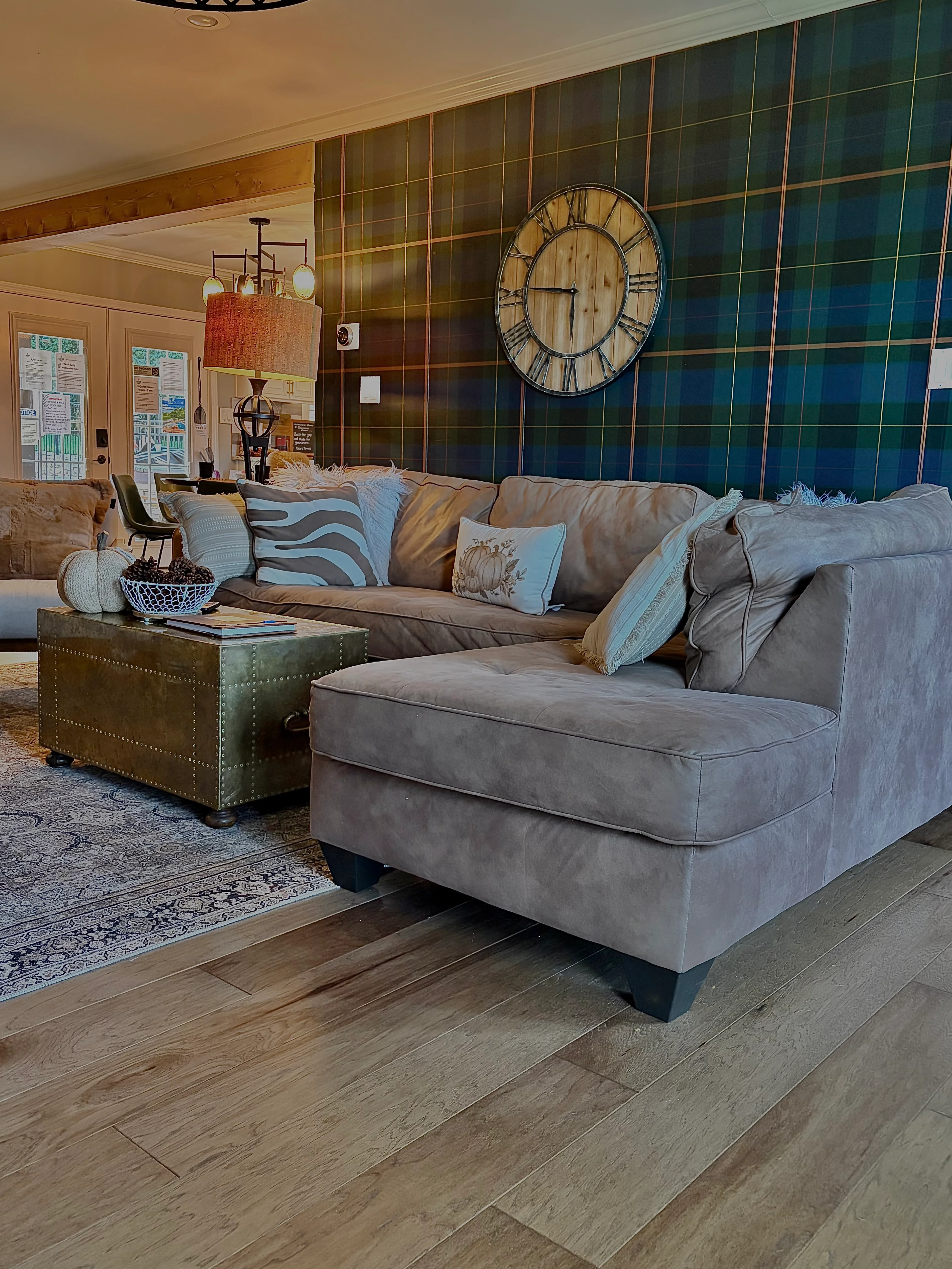 Modern living room with gray sectional sofa and teal gold plaid accent wall, a cozy spot for romantic dinner table ideas in