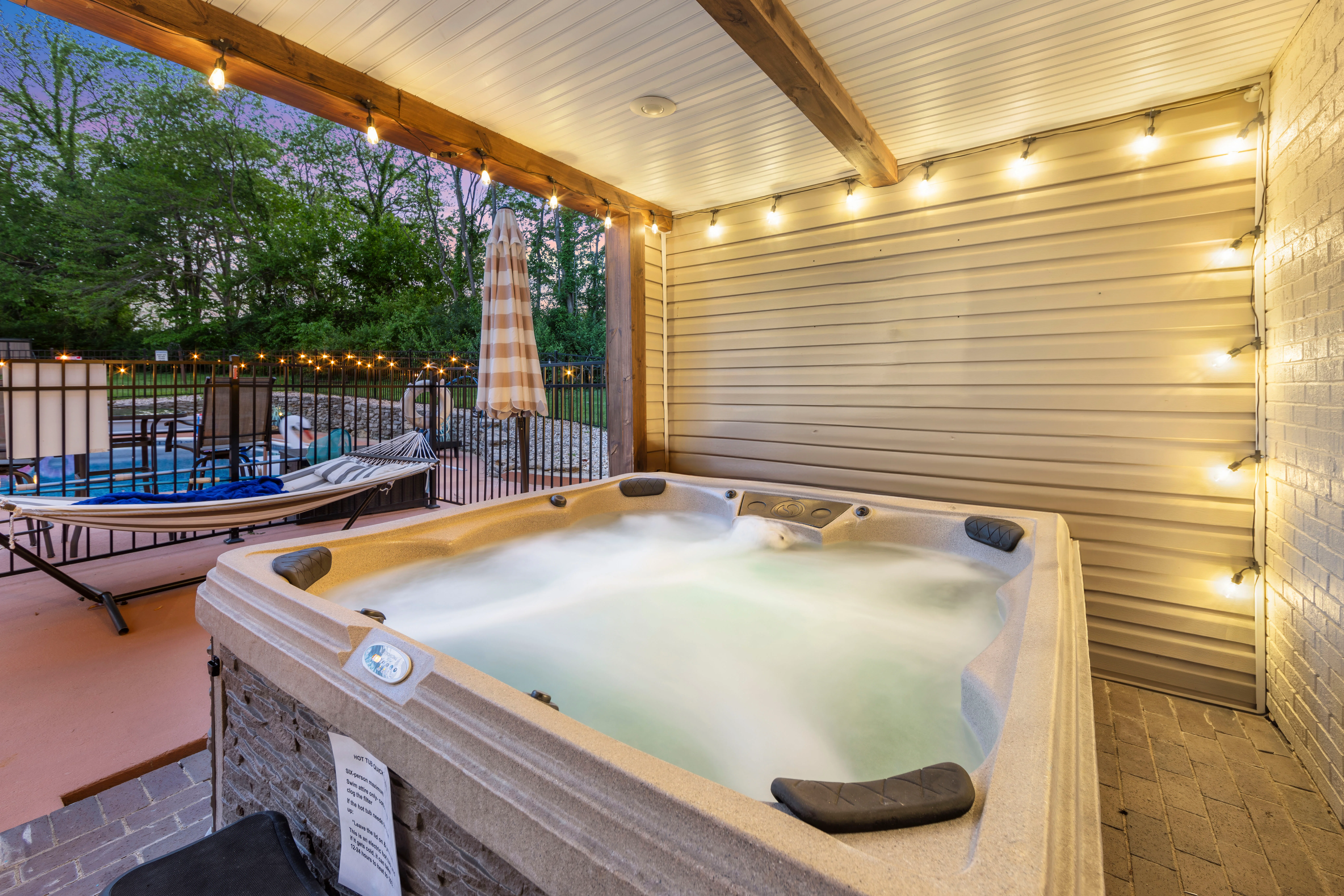 Heated saltwater pool with lounge chairs and string lights at Glencairn Knoll Louisville group rental