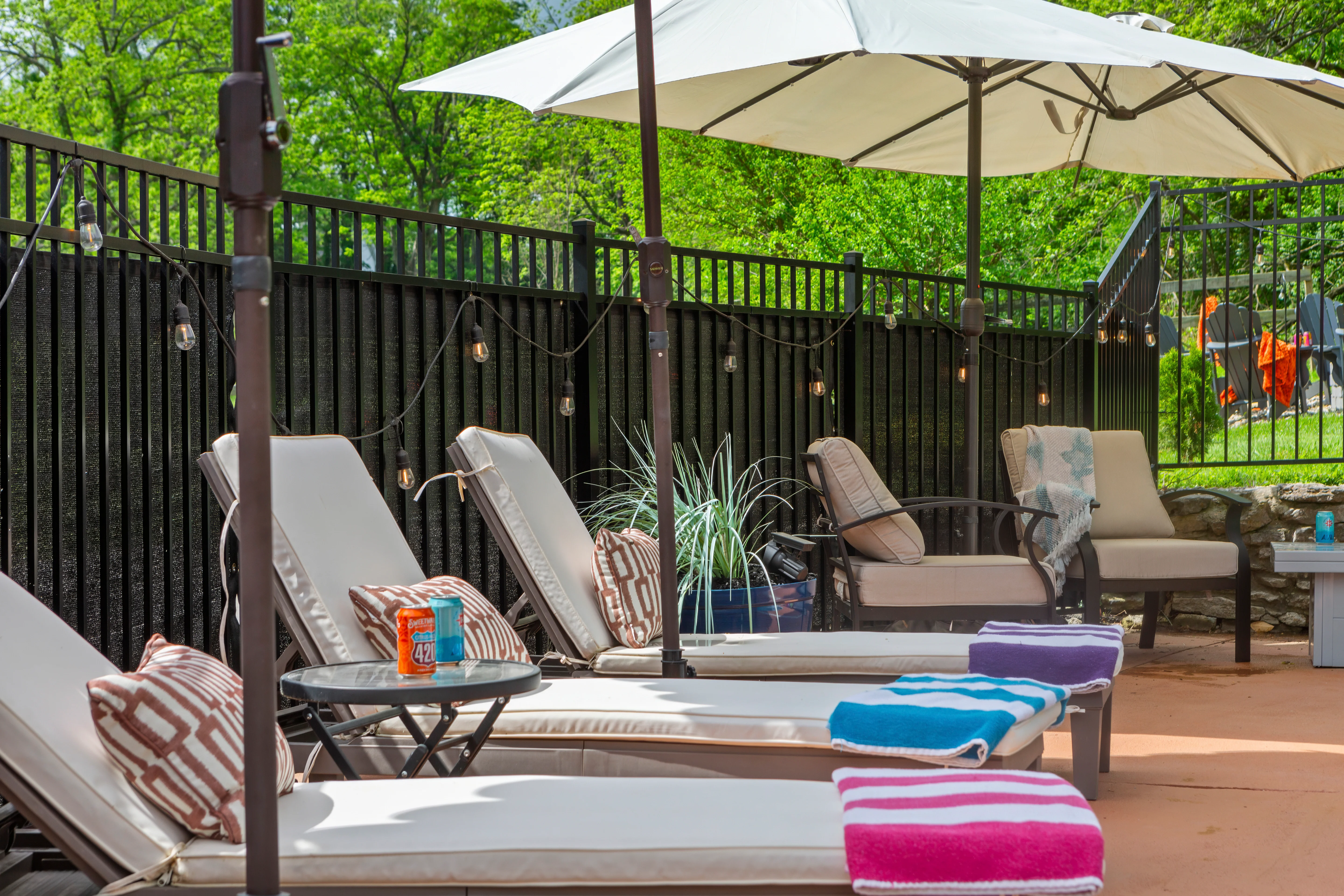 Outdoor speakeasy lounge patio with lounge chairs, umbrellas and ambient lighting at Glencairn Knoll Louisville