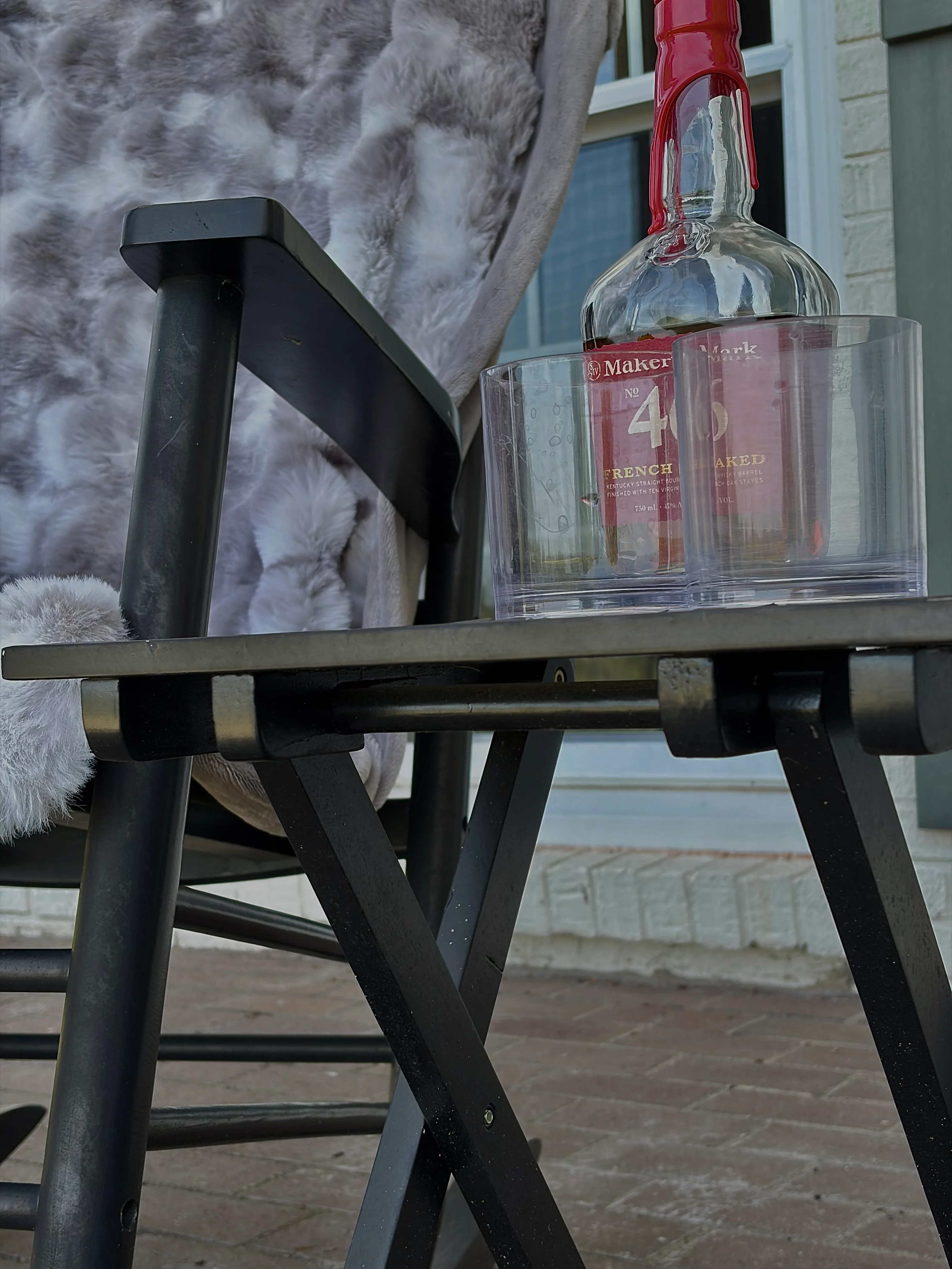 Outdoor patio with Maker's Mark bourbon, whiskey glass, and waterfront view at Glencairn Knoll