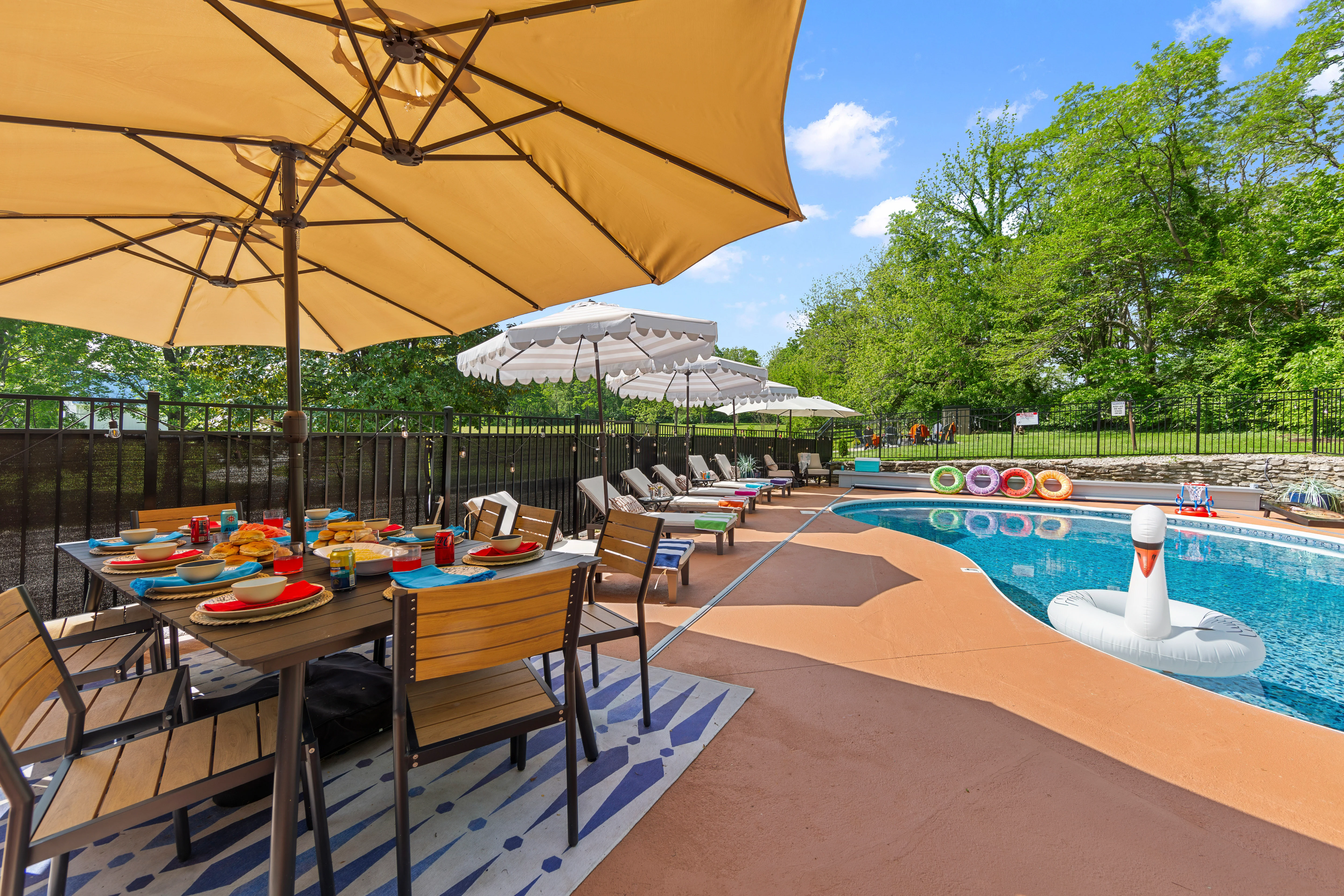 Saltwater pool and patio dining area at a large group getaway Louisville rental in La Grange